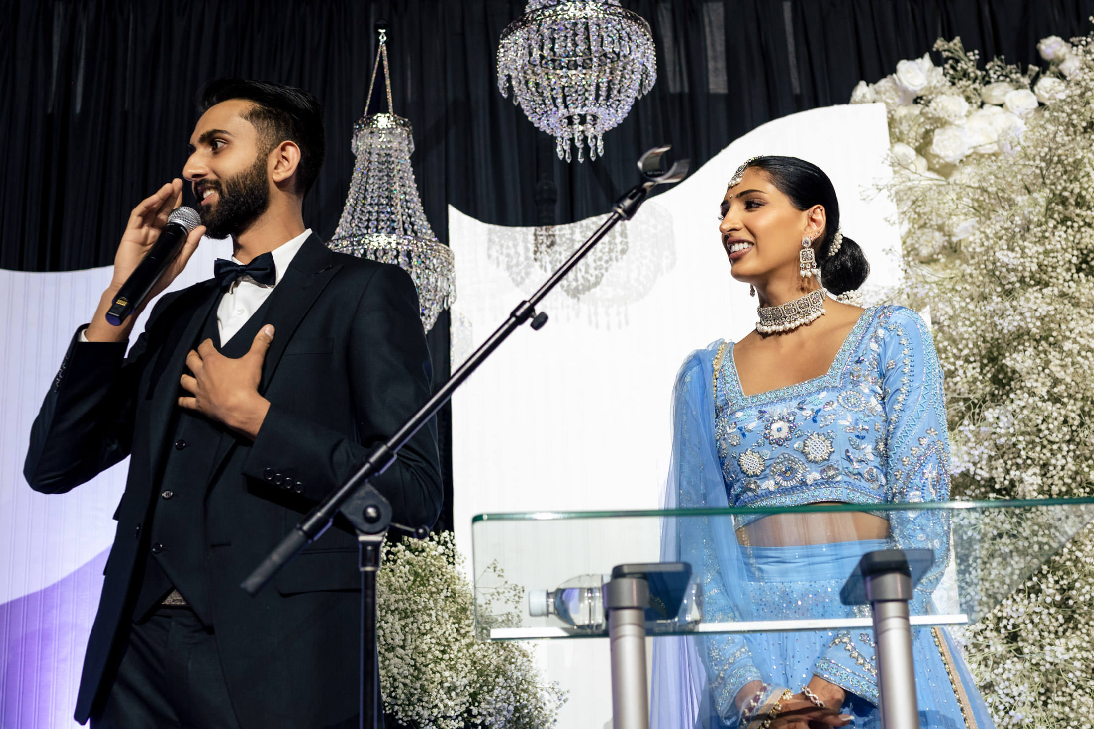 A man and woman speak at a podium, dressed elegantly for a Winnipeg wedding.