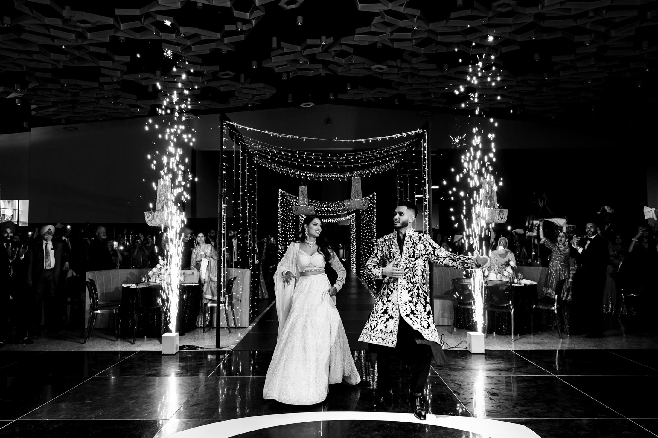 A couple dancing at a Winnipeg wedding with fireworks and decorative lights.