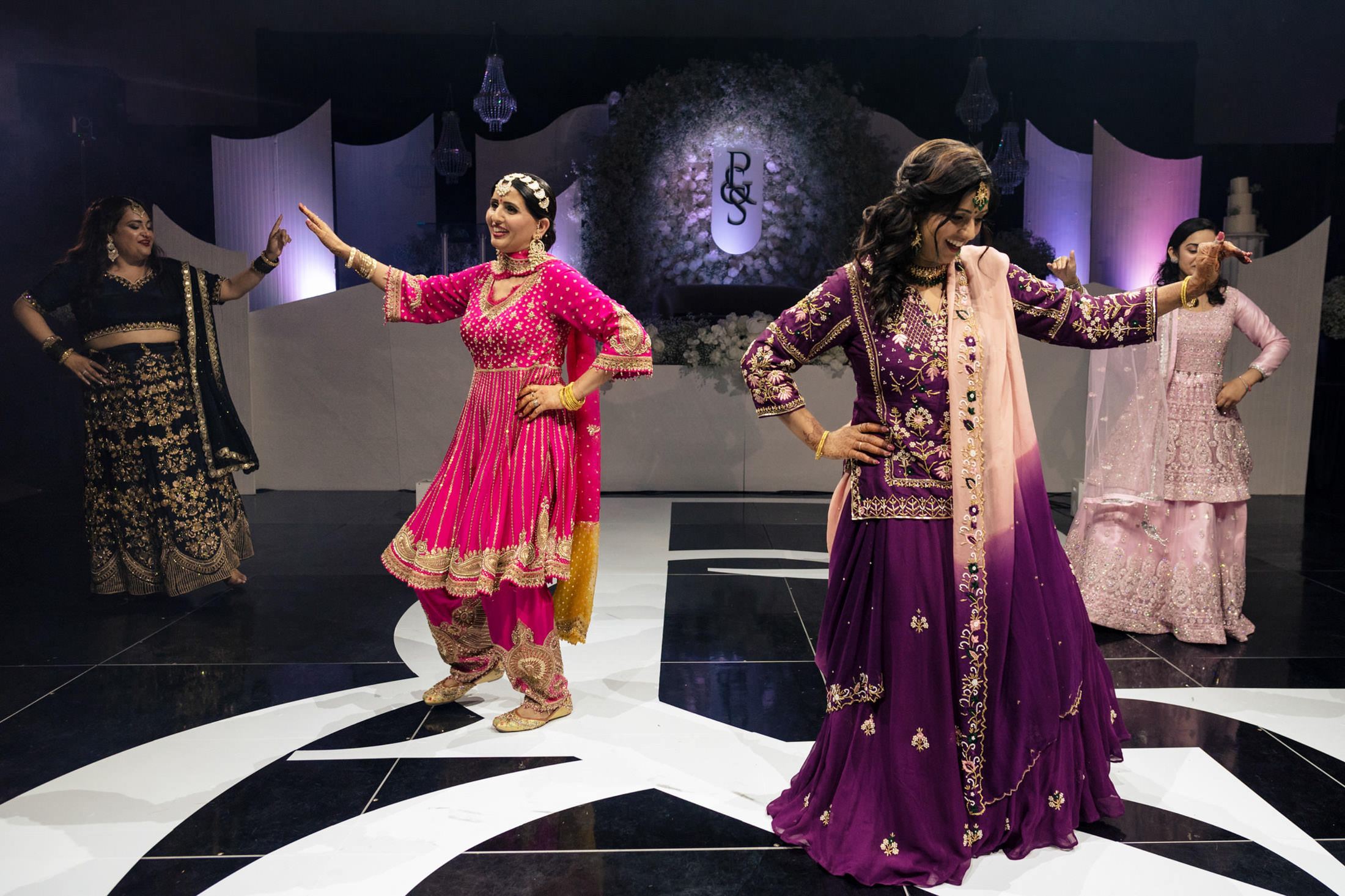People dancing in colorful traditional outfits at a vibrant Winnipeg wedding.