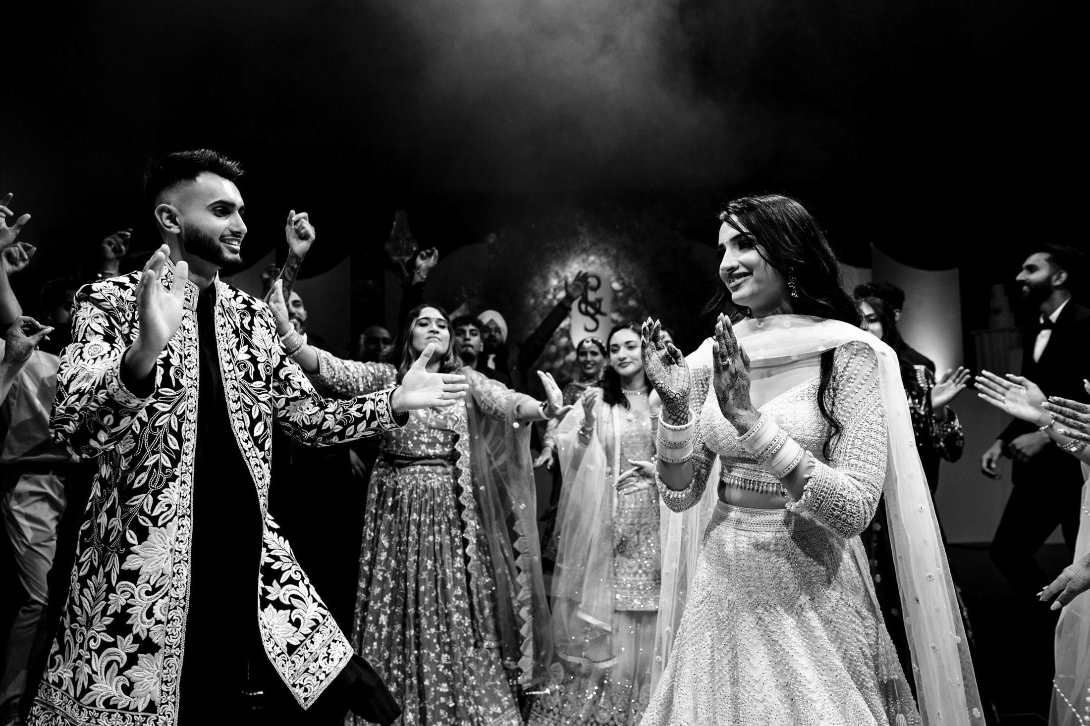 Couple dancing joyfully at a Winnipeg wedding, with guests joining in the celebration.