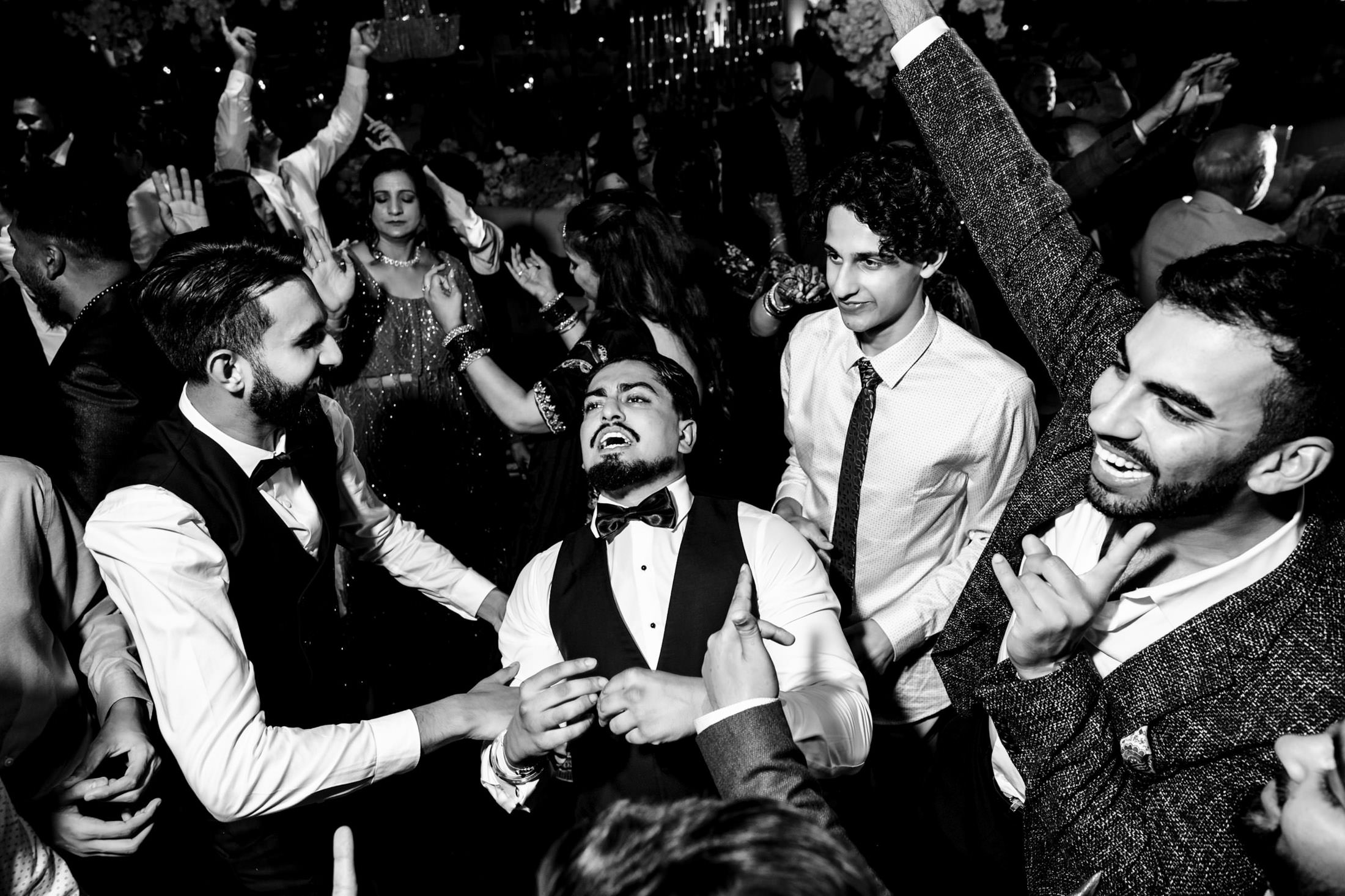 Guests in formal attire joyfully dancing at a lively Winnipeg wedding celebration.