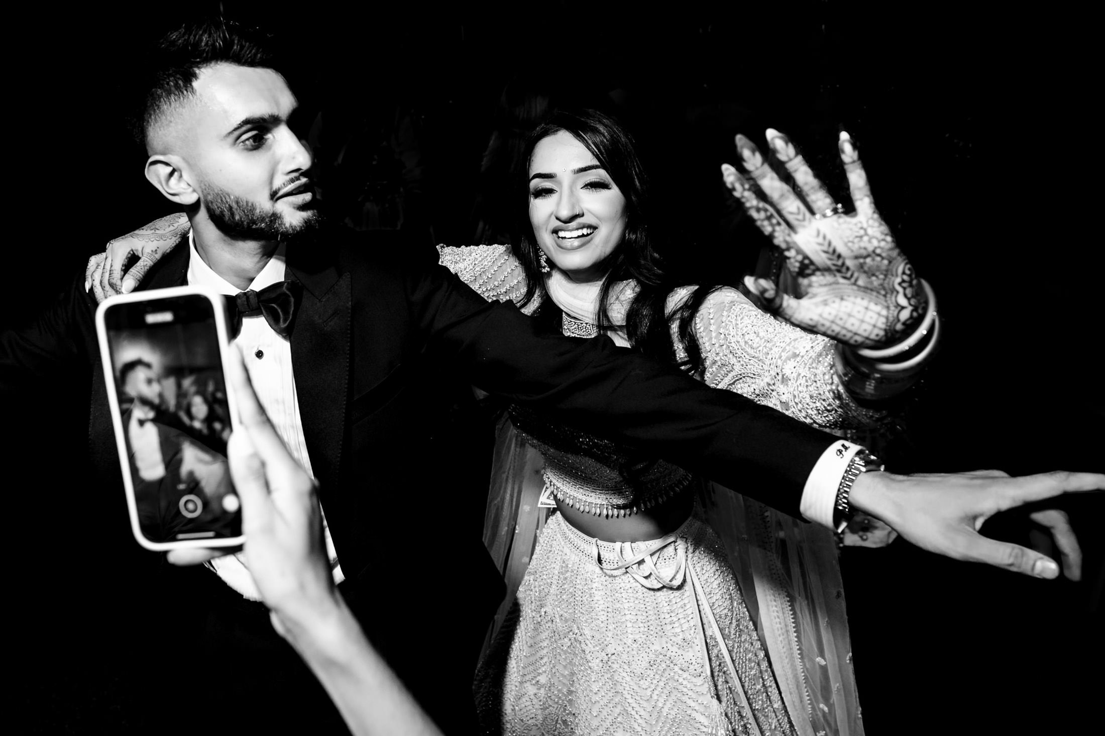 A couple dancing at a Winnipeg wedding, with a phone capturing the moment.