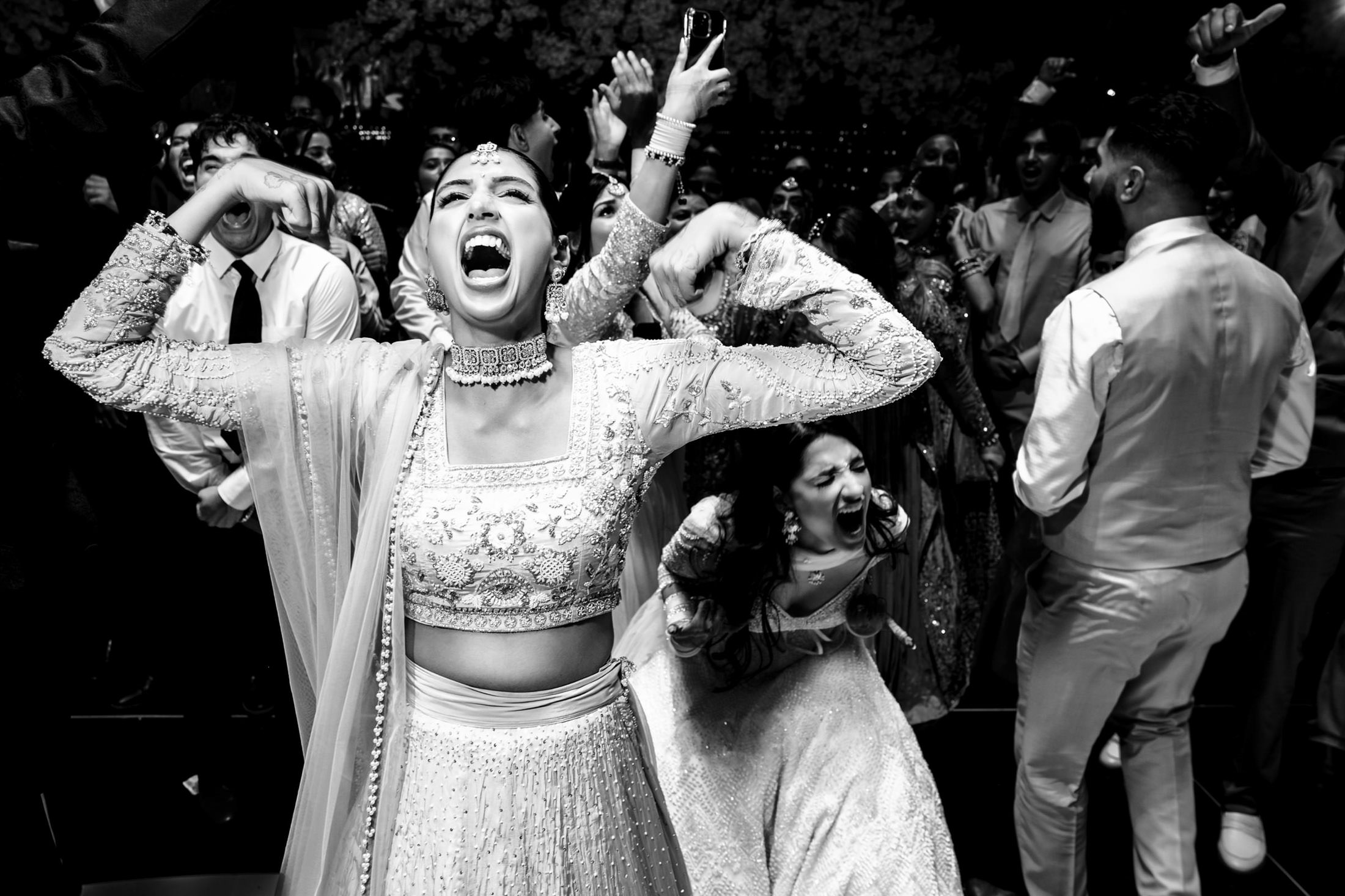 Woman in traditional attire joyfully celebrating at a lively Winnipeg wedding event.