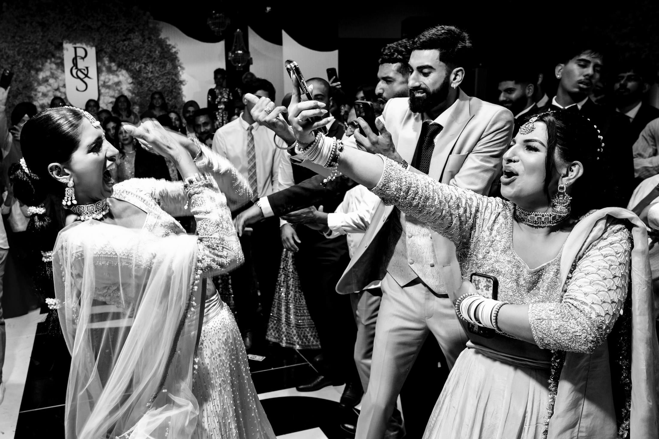 Guests joyfully dancing and taking selfies at a Winnipeg wedding celebration.