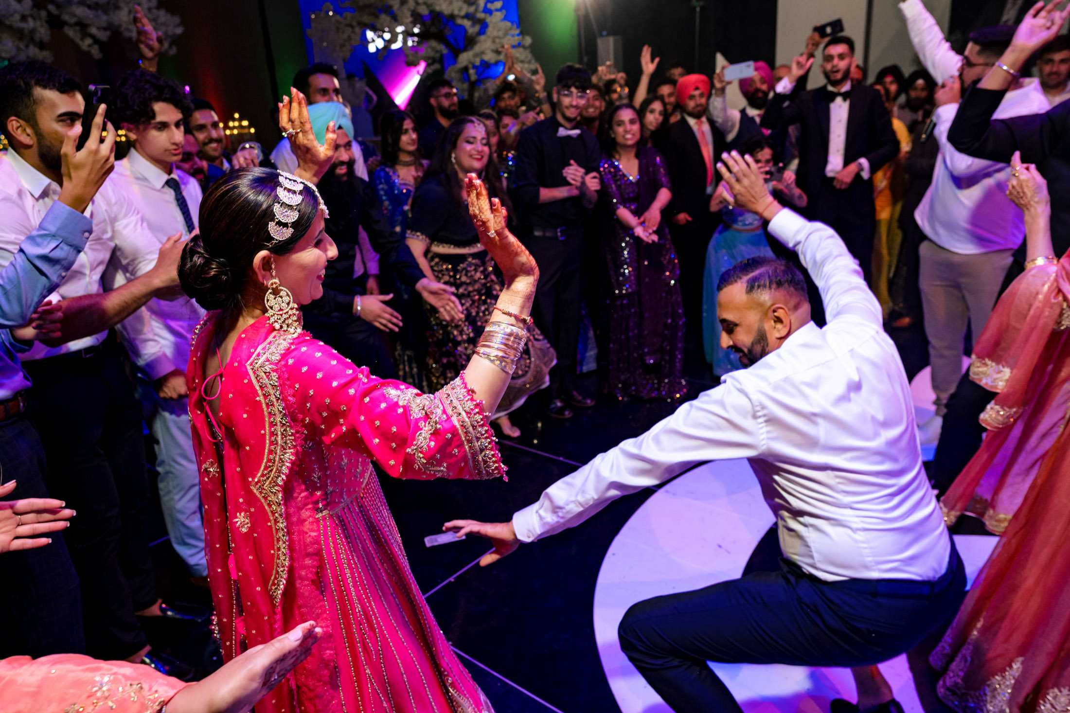 People dancing energetically at a vibrant Winnipeg wedding celebration.