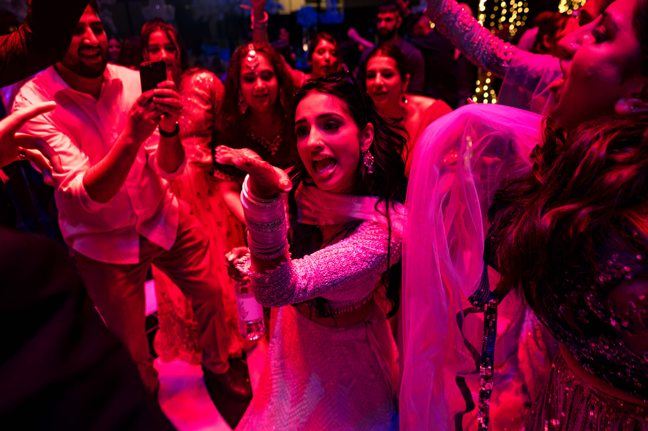 People dancing energetically at a Winnipeg wedding, capturing joy and colorful excitement.