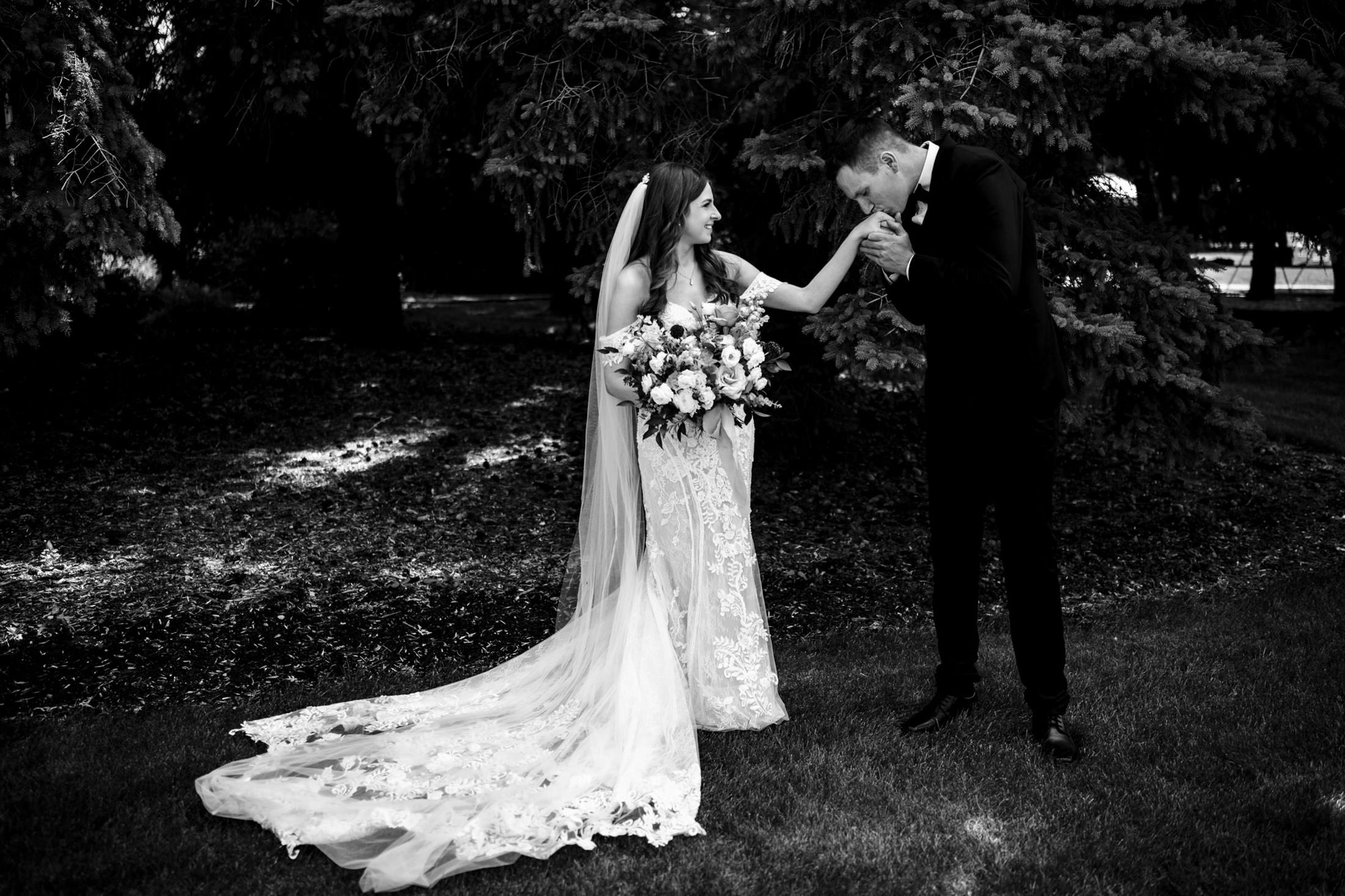Bride and groom share a tender moment at Ashgrove Acres' lush garden setting.