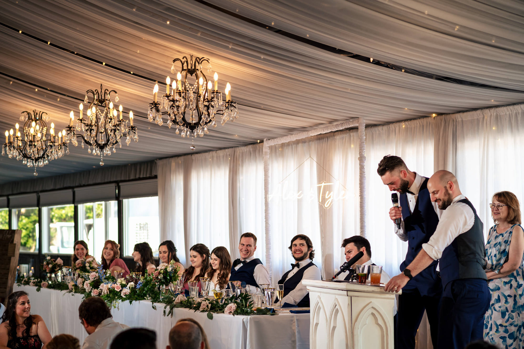 Wedding speeches at Ashgrove Acres with guests listening attentively in a decorated reception.