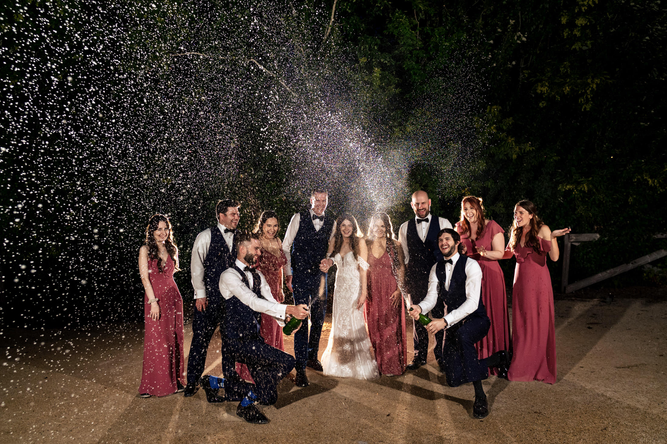 At Ashgrove Acres, the wedding party revels in champagne under a bubble-lit night sky.