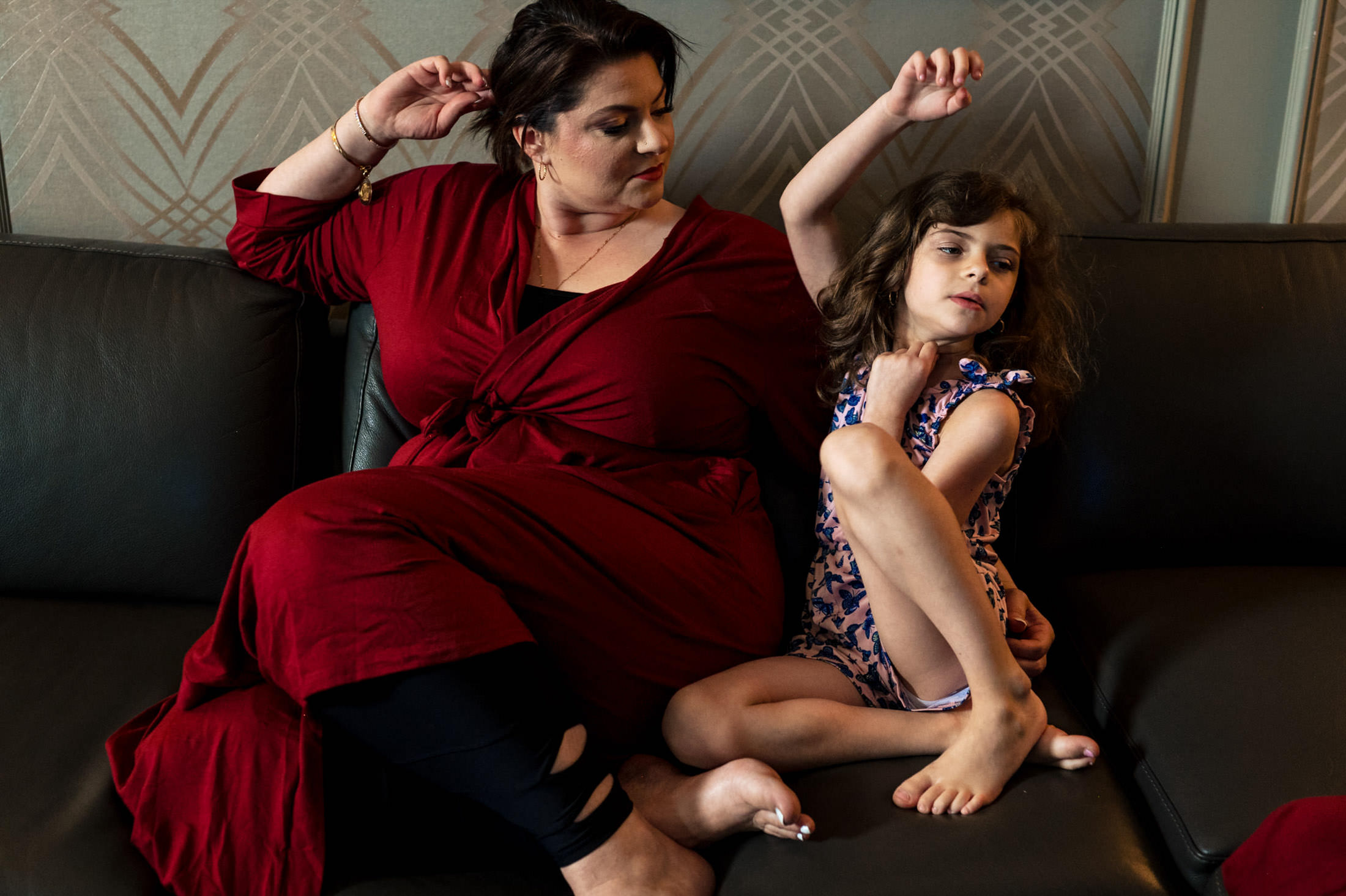 Adult and child on a sofa, arms stretching like joyful guests at an Italian wedding.
