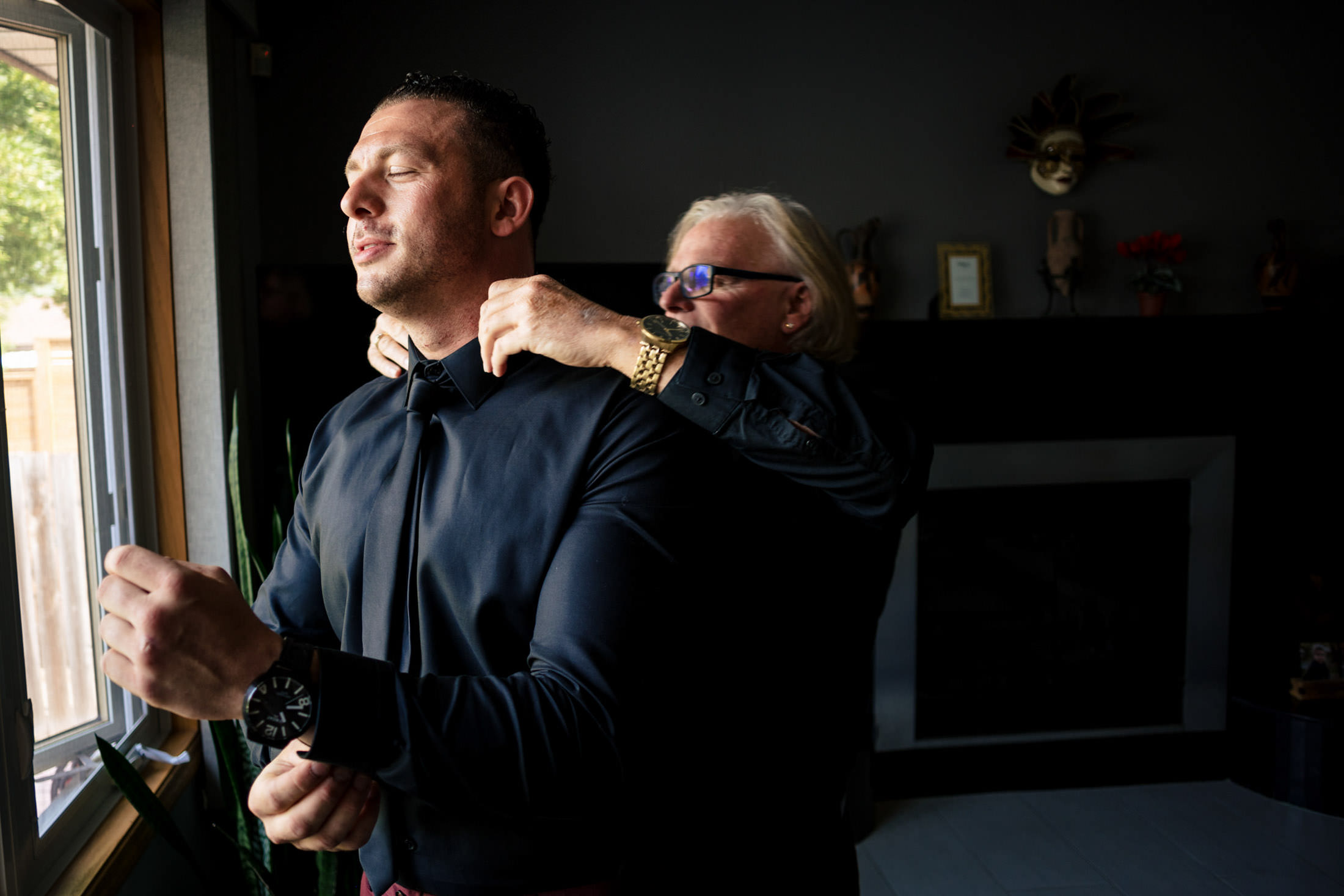 A man adjusts another's tie at an Italian wedding in Winnipeg.