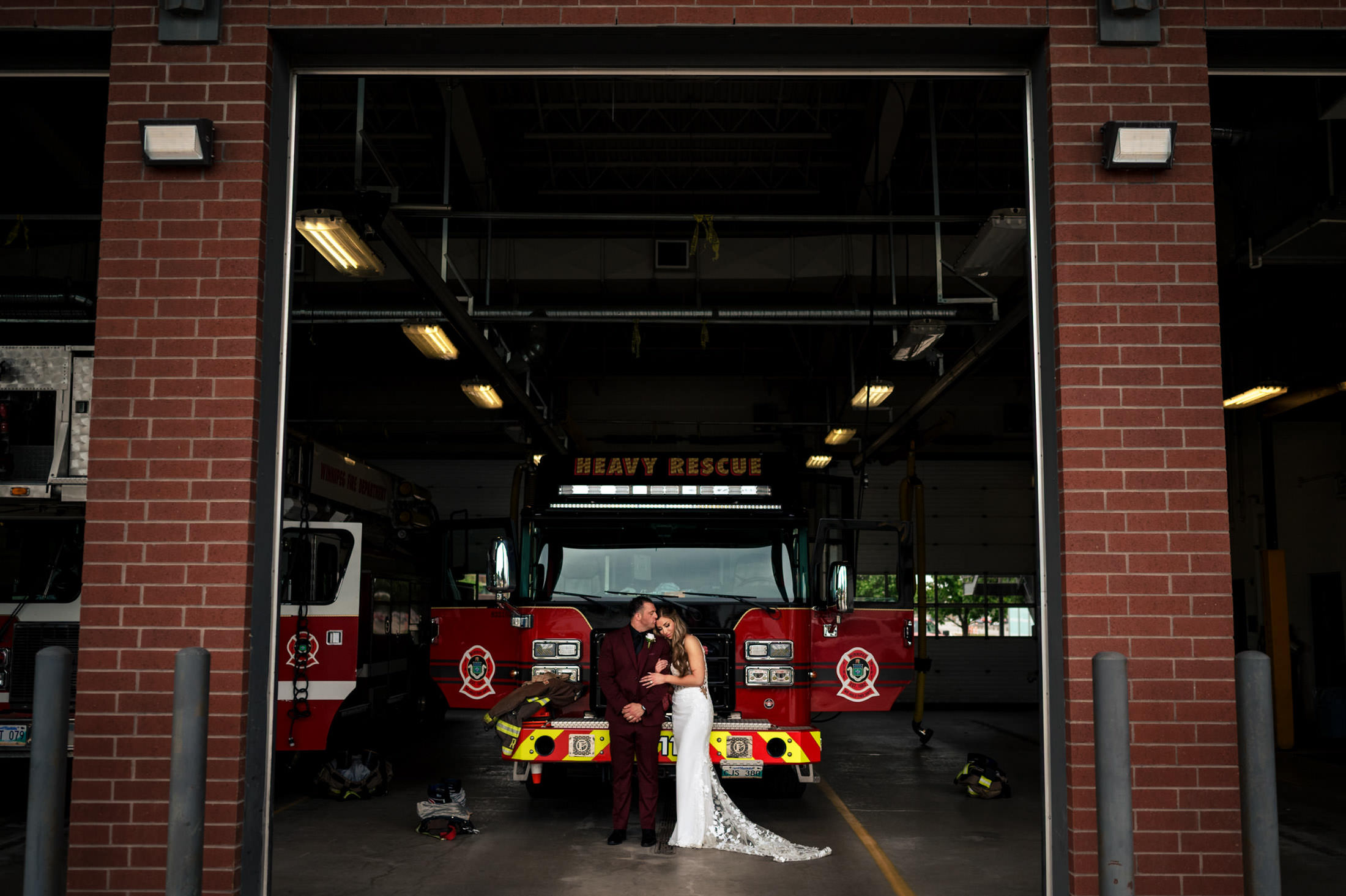 Bride and groom kiss at an Italian wedding in a brick fire station in Winnipeg.