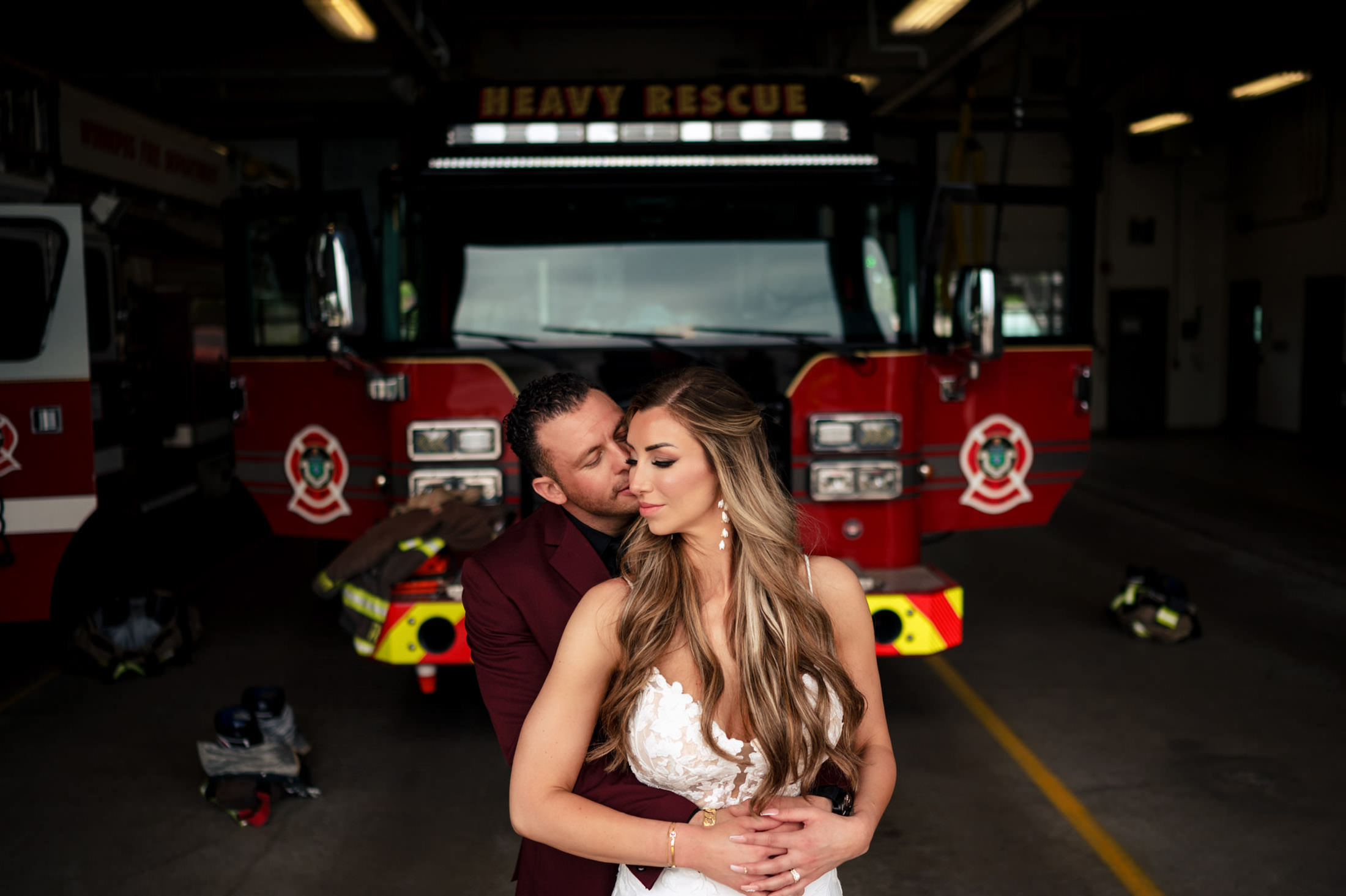 Italian wedding in winnipeg. a couple embracing near a fire truck at a Winnipeg fire station.