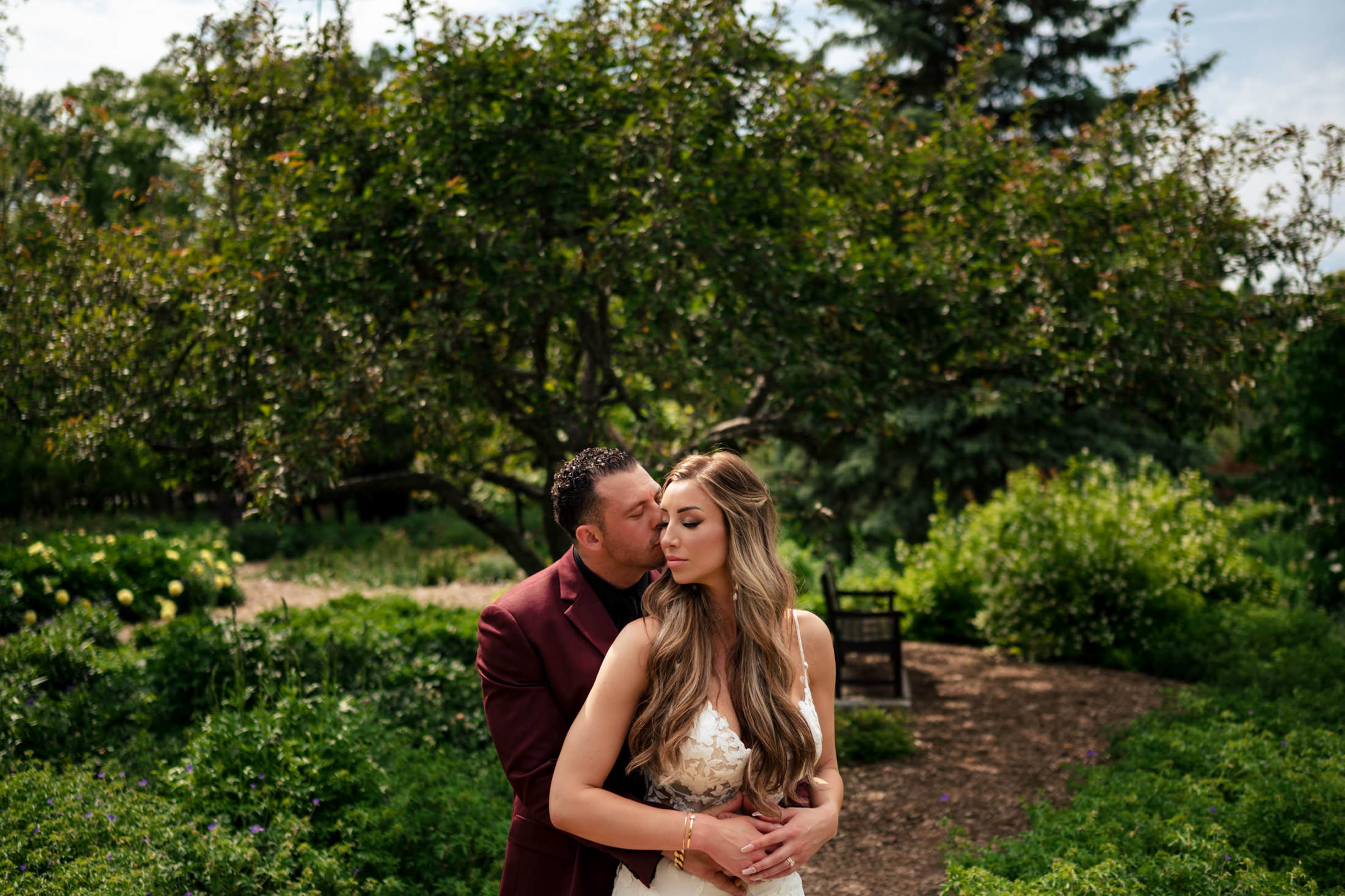 Couple embracing in a lush garden, echoing an Italian wedding in Winnipeg.