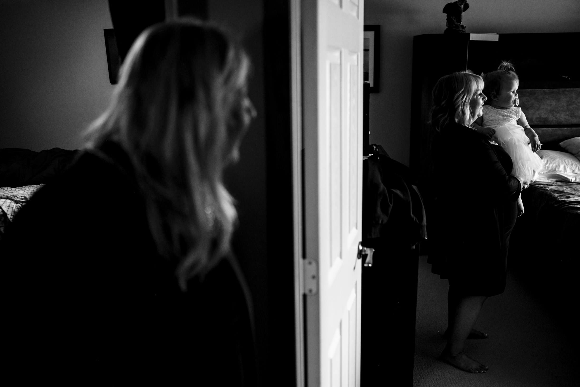 Black and white image of a woman with her baby, reflected in a Snow Lake wedding mirror.
