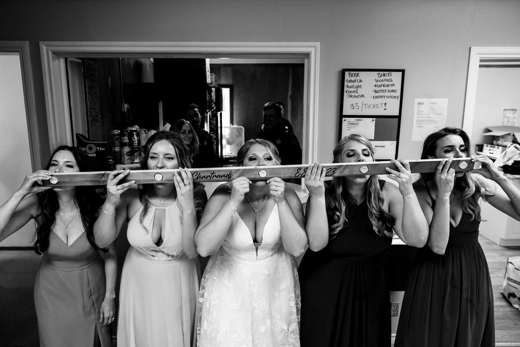Five people in dresses taking ski shots together at a lively Snow Lake wedding.