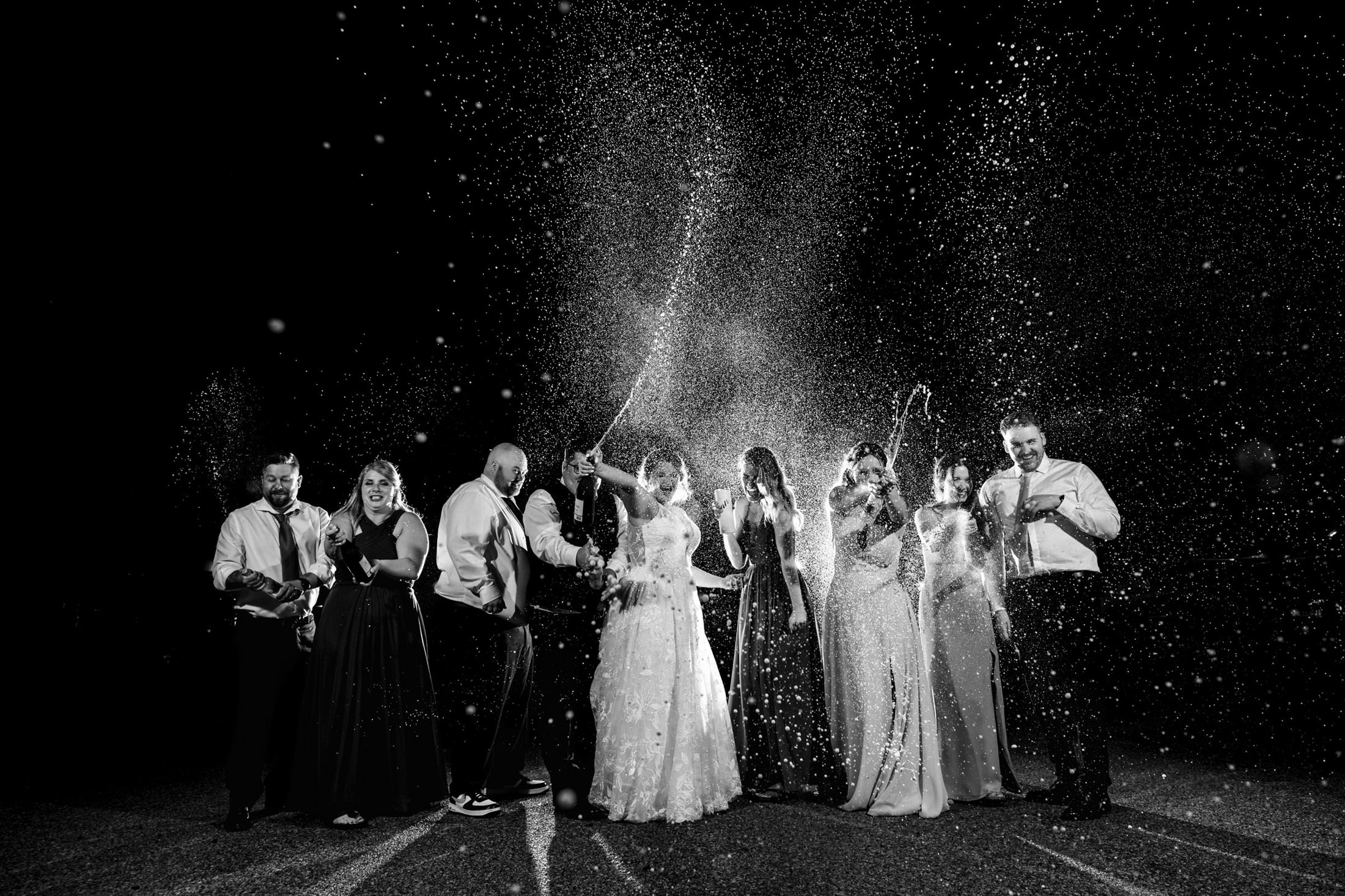 People celebrating with champagne at a wedding at Snow Lake, dressed in formal attire.