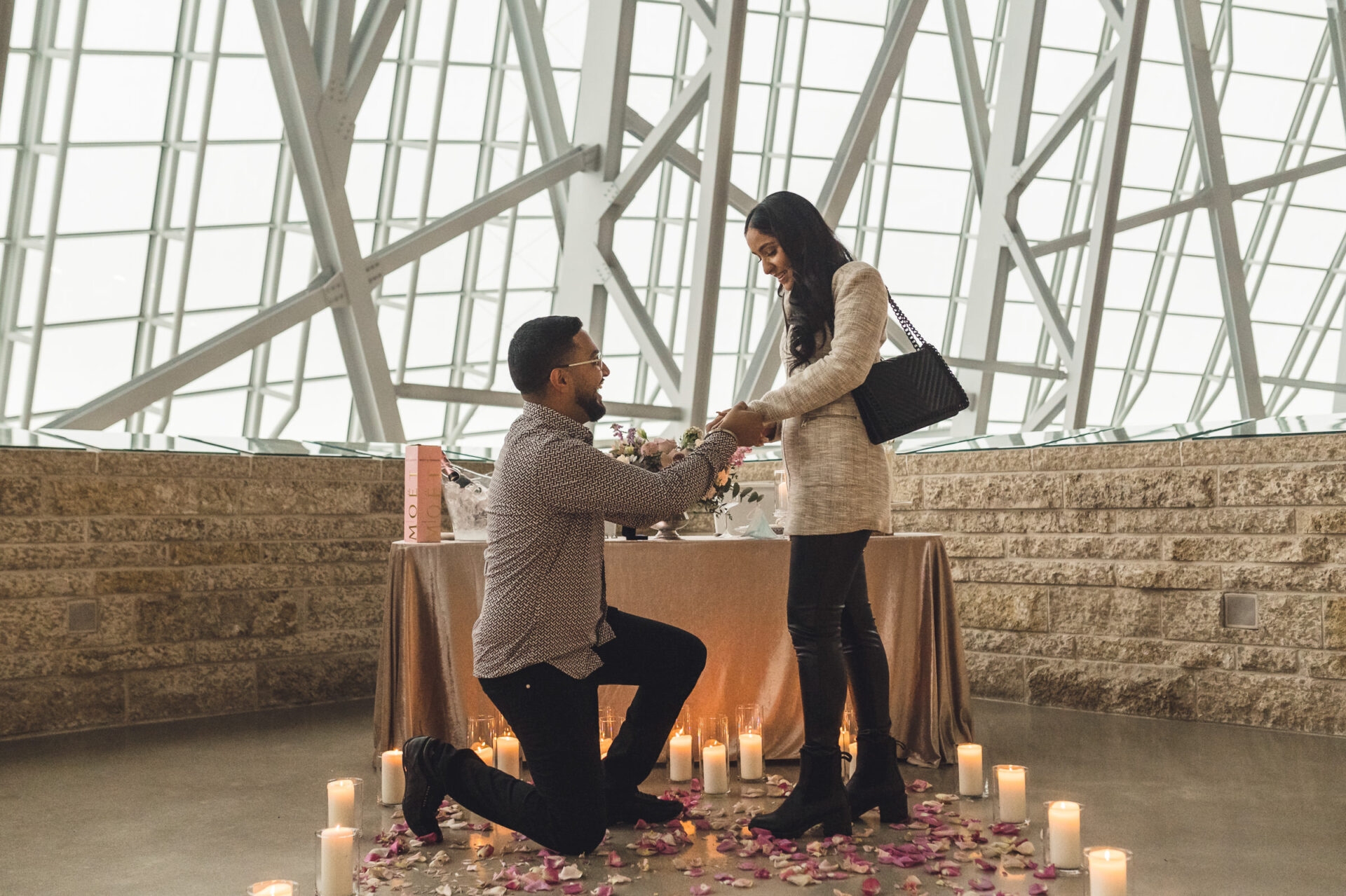 In a modern setting, best Winnipeg wedding photos capture a proposal amid candles and rose petals.