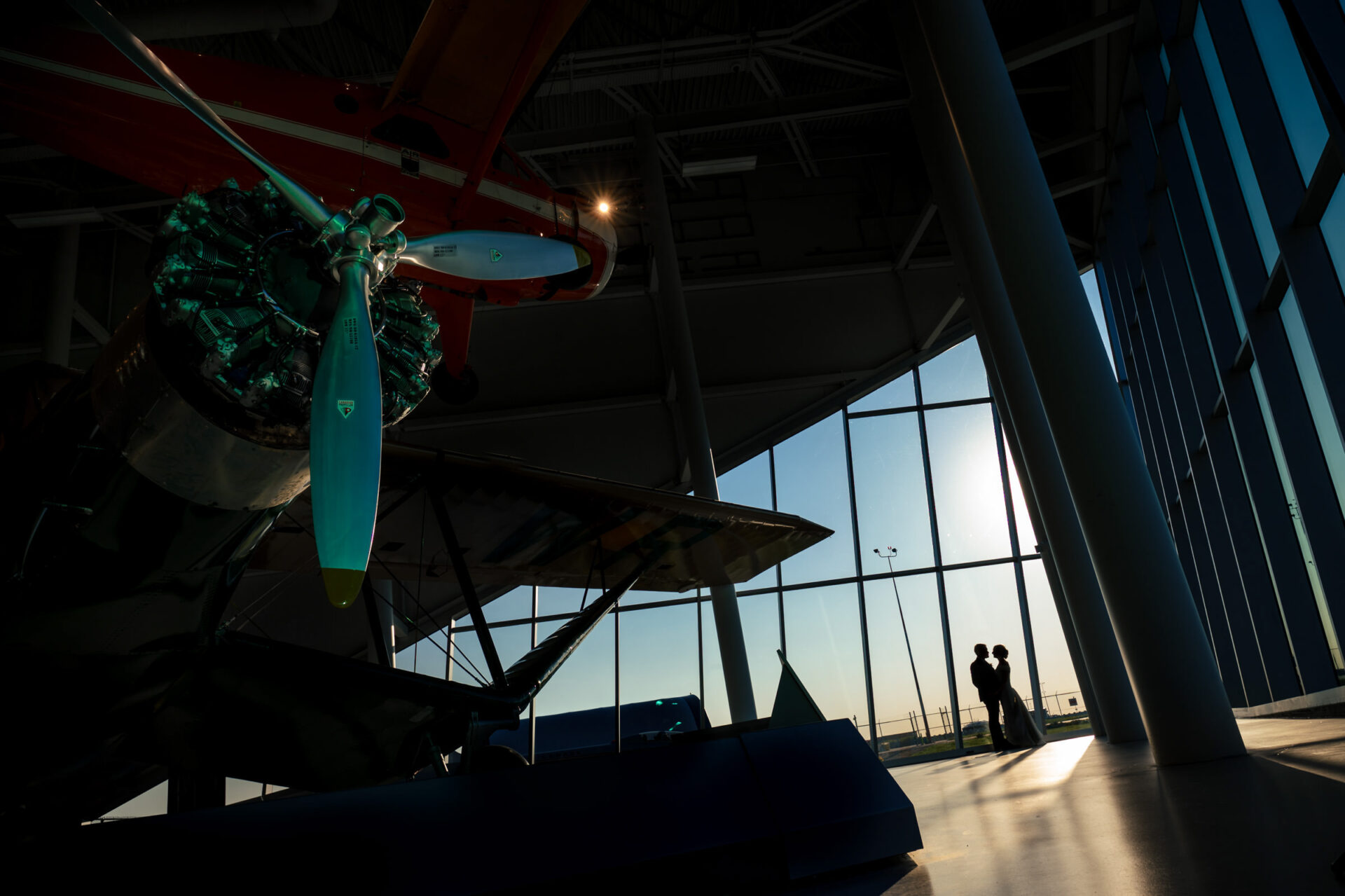 Silhouetted by sunlight, a plane sets the scene for the best Winnipeg wedding photos.