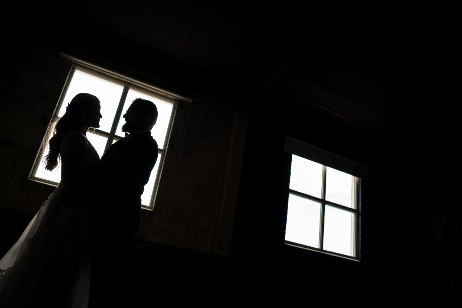 Silhouette of a couple embracing by a window, best Winnipeg wedding photo.