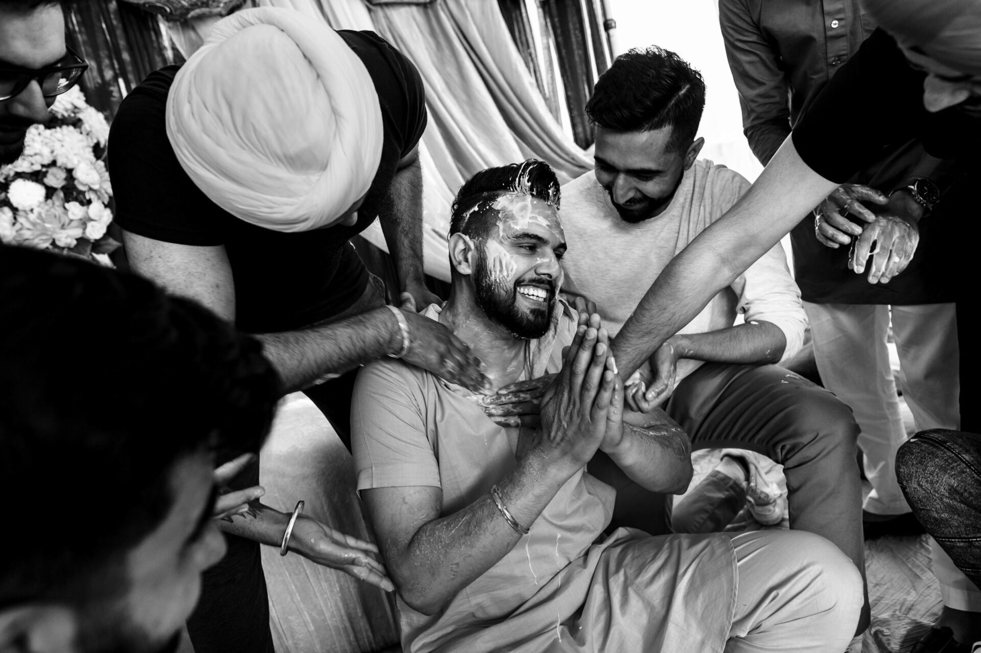 A man joyfully covered in paste, surrounded by friends at the best Winnipeg wedding photos.
