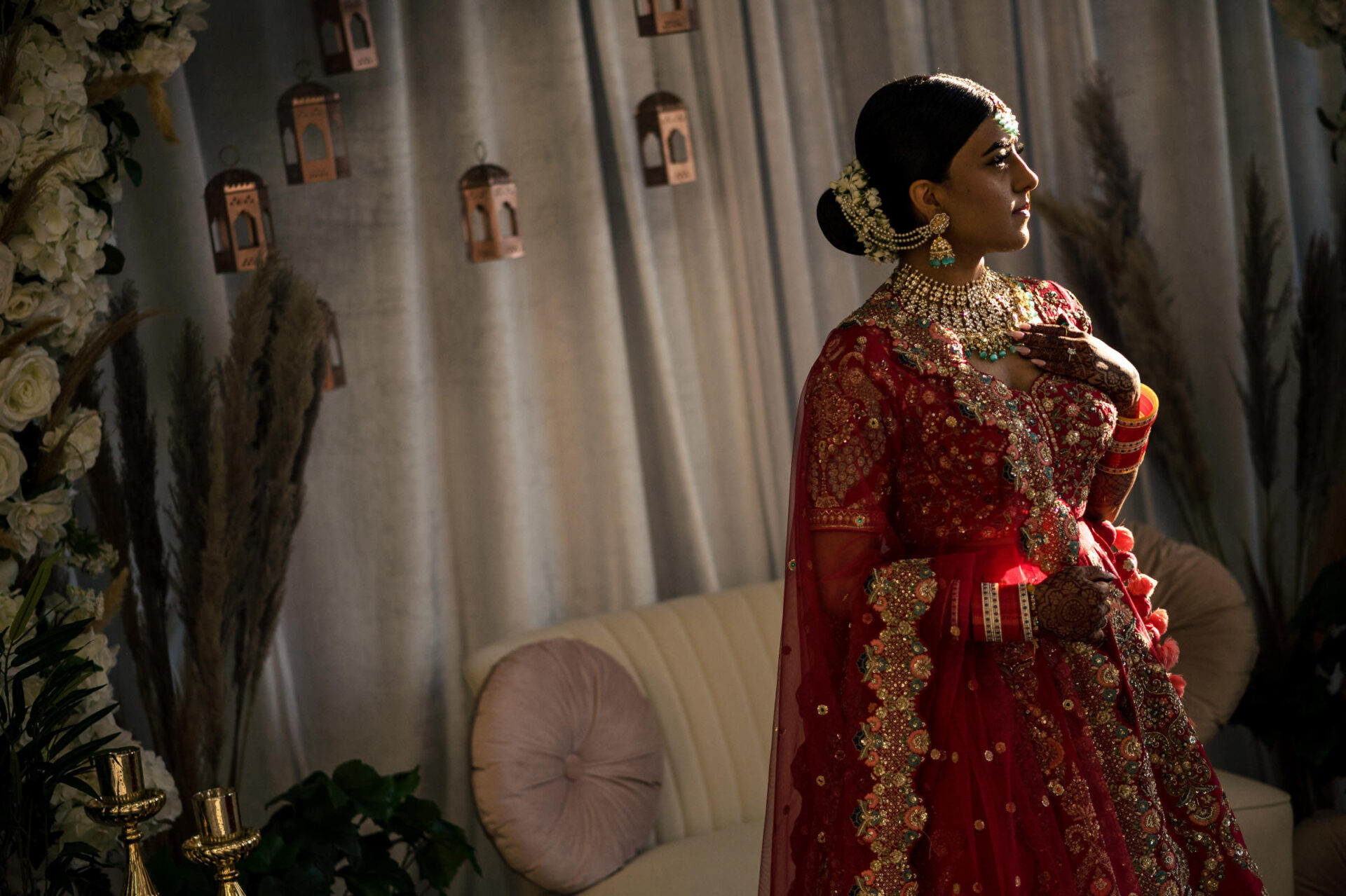 Bride in red standing with soft light and floral decor for the best Winnipeg wedding photos.