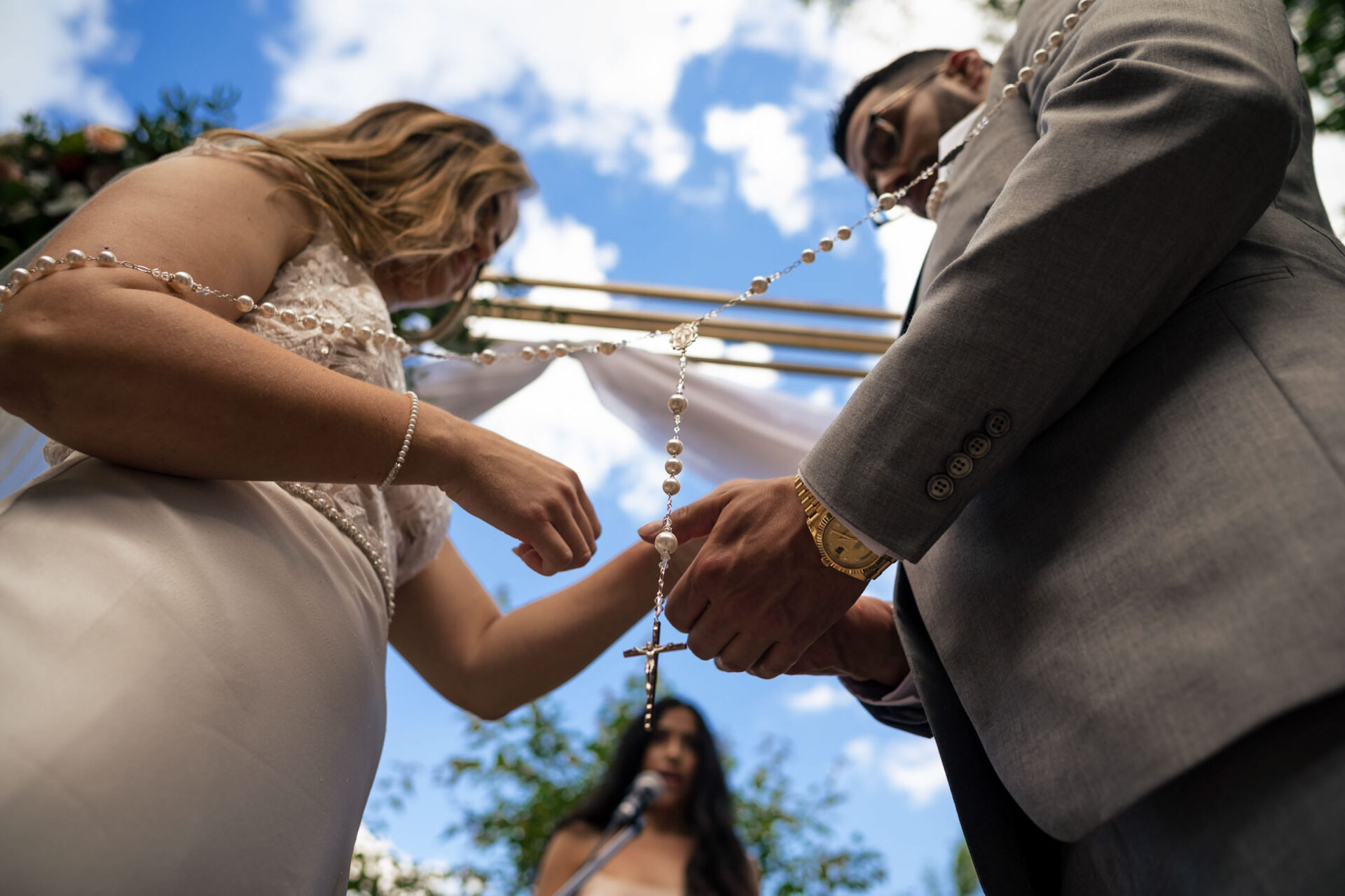 Couple holding a rosary during an outdoor wedding, capturing the best Winnipeg wedding moments.