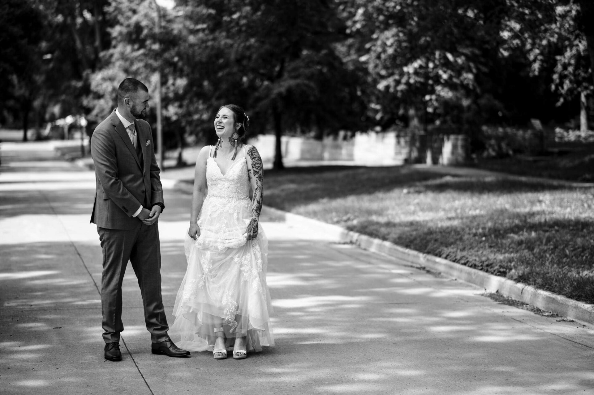 Bride and groom smiling on a sunlit walkway, capturing Best Winnipeg Wedding Photos.