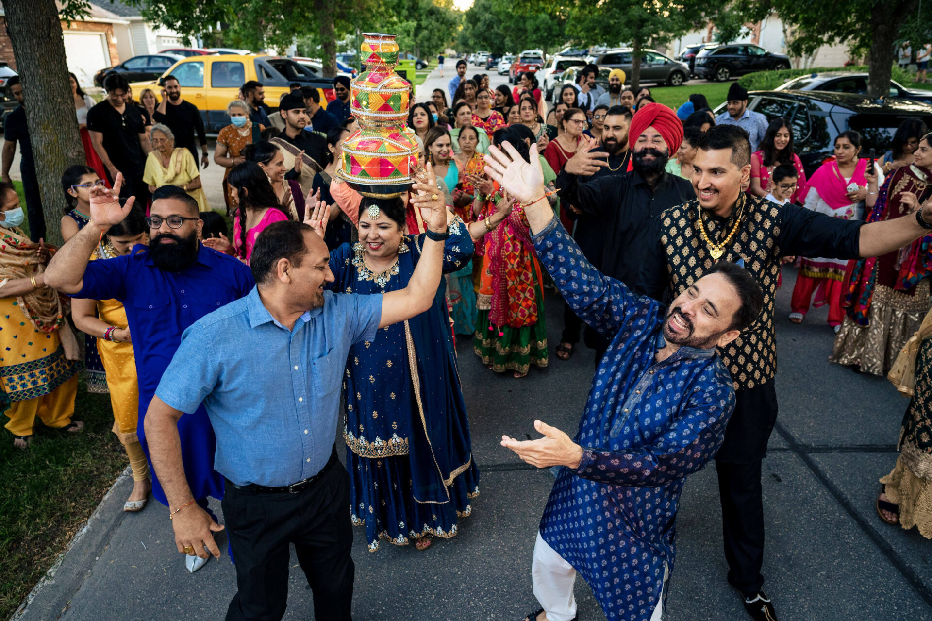 Best Winnipeg wedding photos showcase people in colorful attire, some with decorative pots.