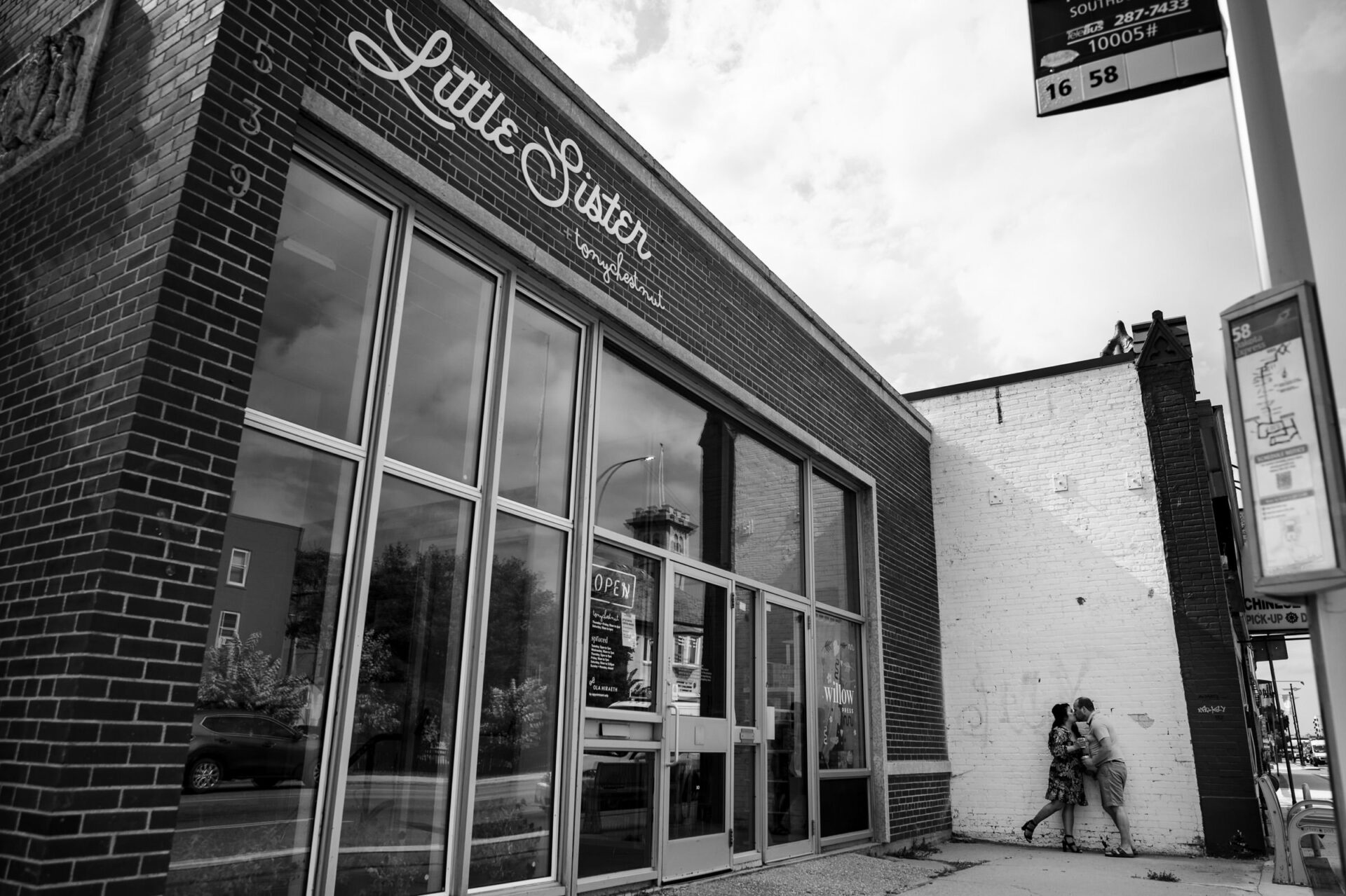 Best Winnipeg Wedding Photos: Black and white image of a storefront with two people nearby.
