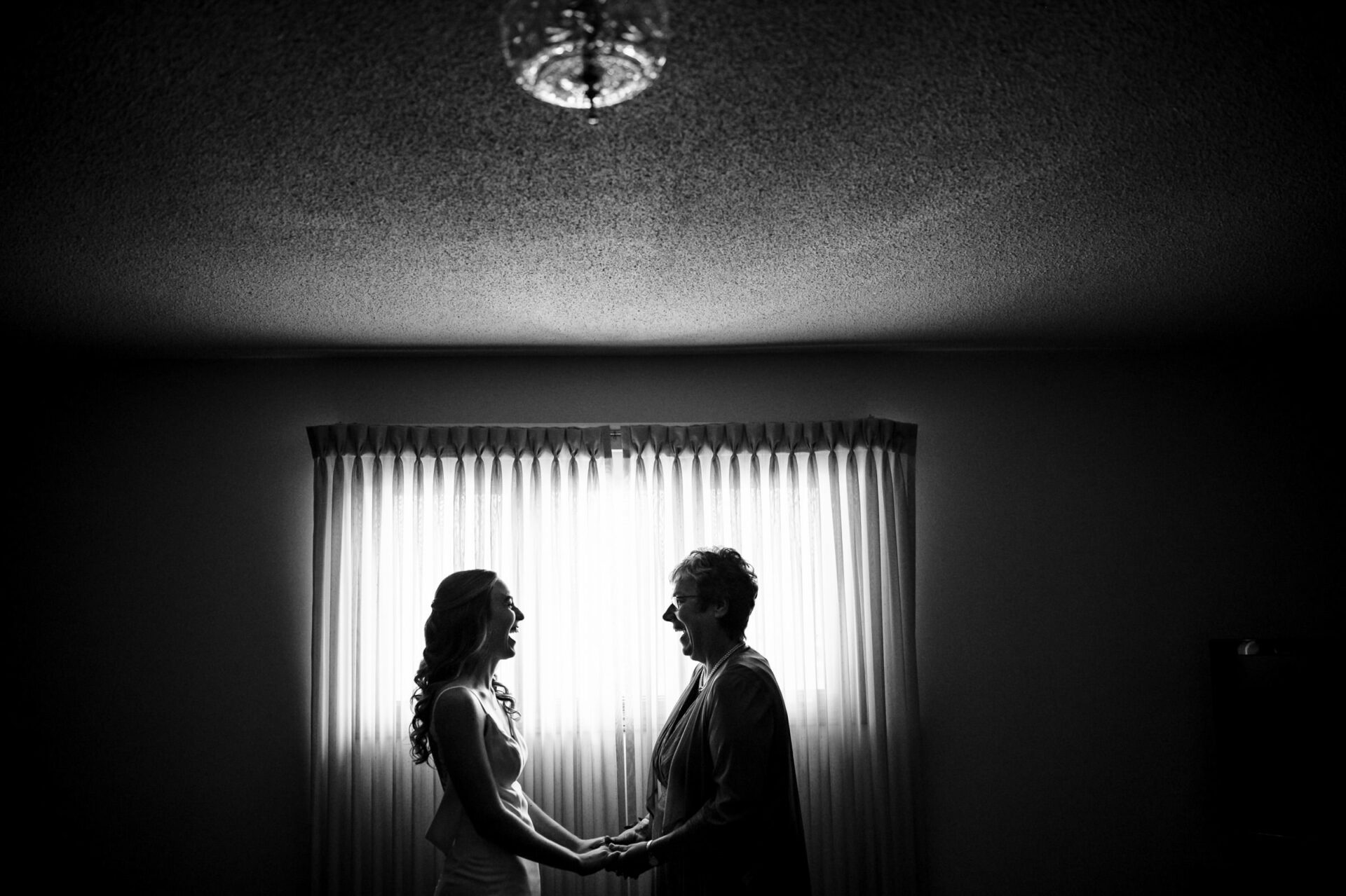 Silhouettes of two people holding hands, a best Winnipeg wedding photo moment.