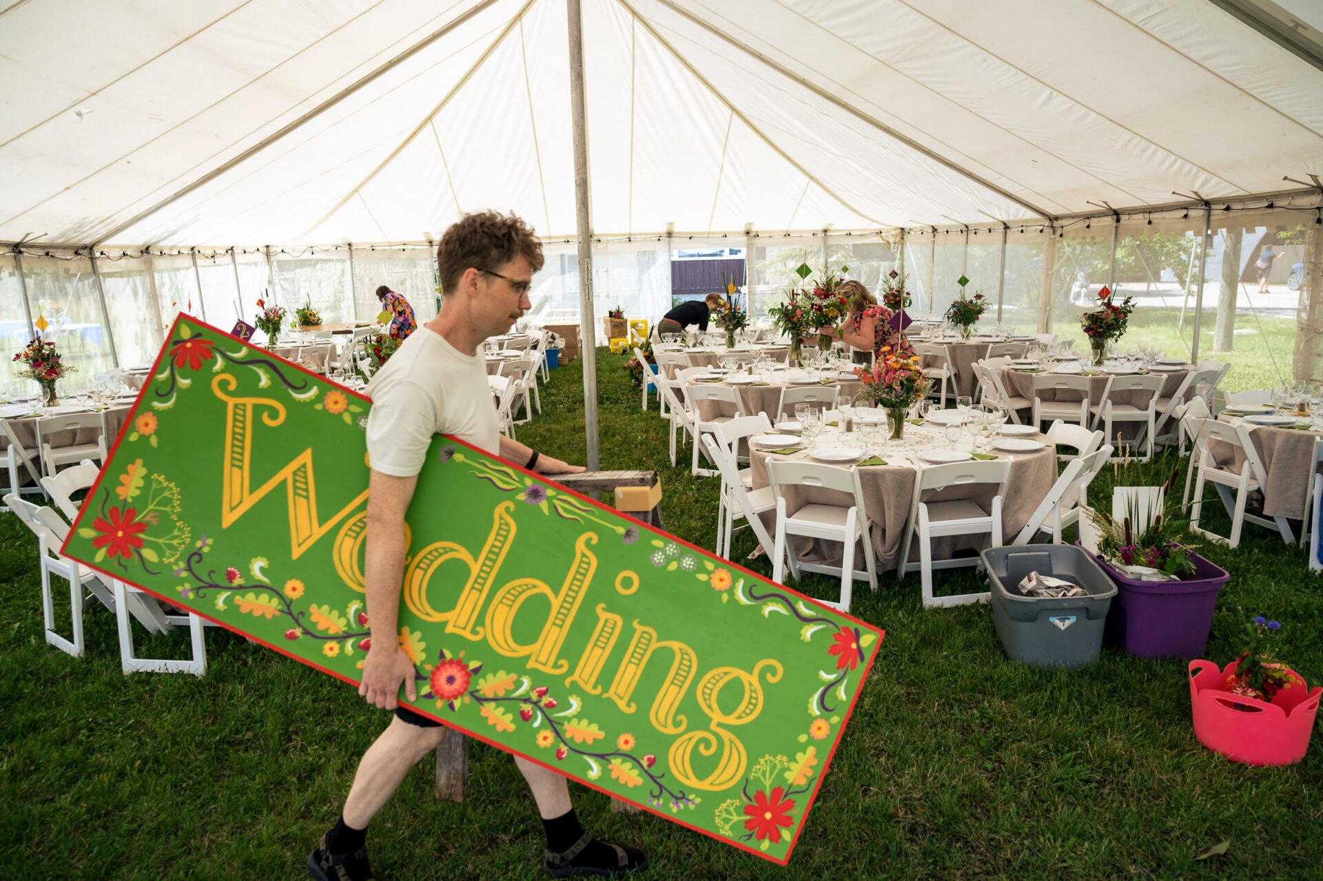 Man carrying "Wedding" sign in tent, perfect for Best Winnipeg Wedding Photos.