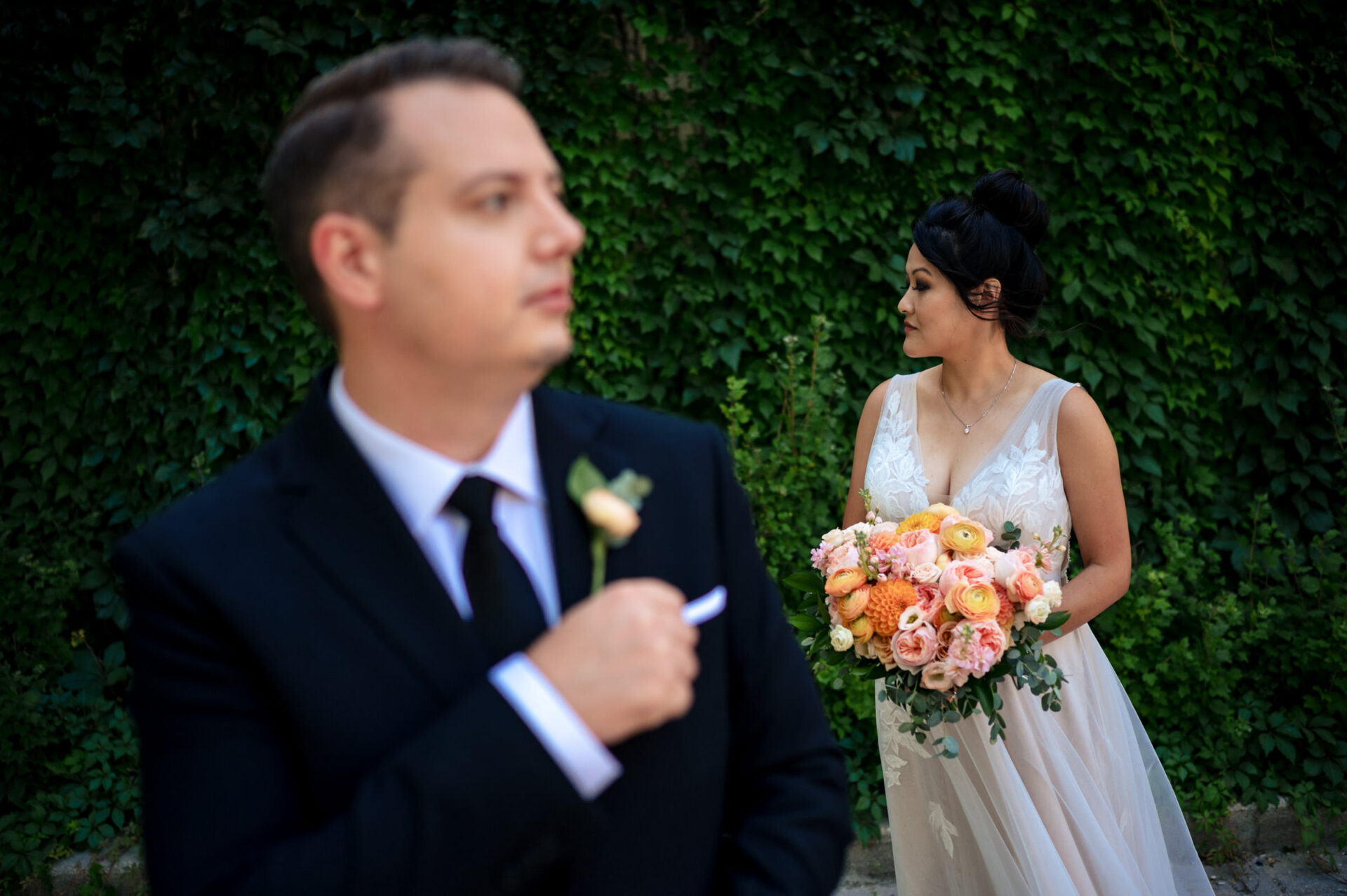 Bride holds bouquet as groom adjusts boutonniere; Best Winnipeg Wedding Photos background.