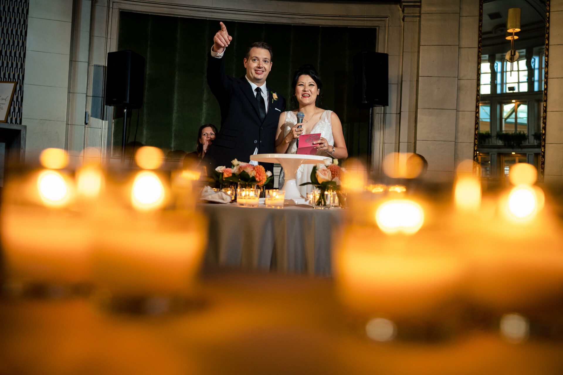 A couple, featured in Best Winnipeg Wedding Photos, gives a speech at a candlelit reception.