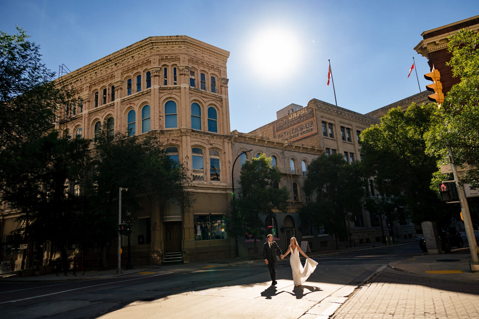 Couple holding hands on sunlit streets, perfect for best Winnipeg wedding photos.