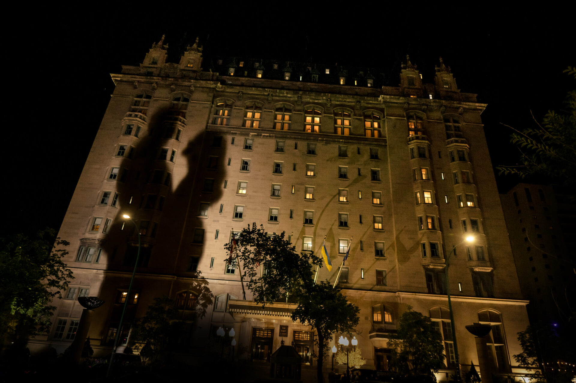 Tall, illuminated hotel at night captures best Winnipeg wedding photos through lit windows.