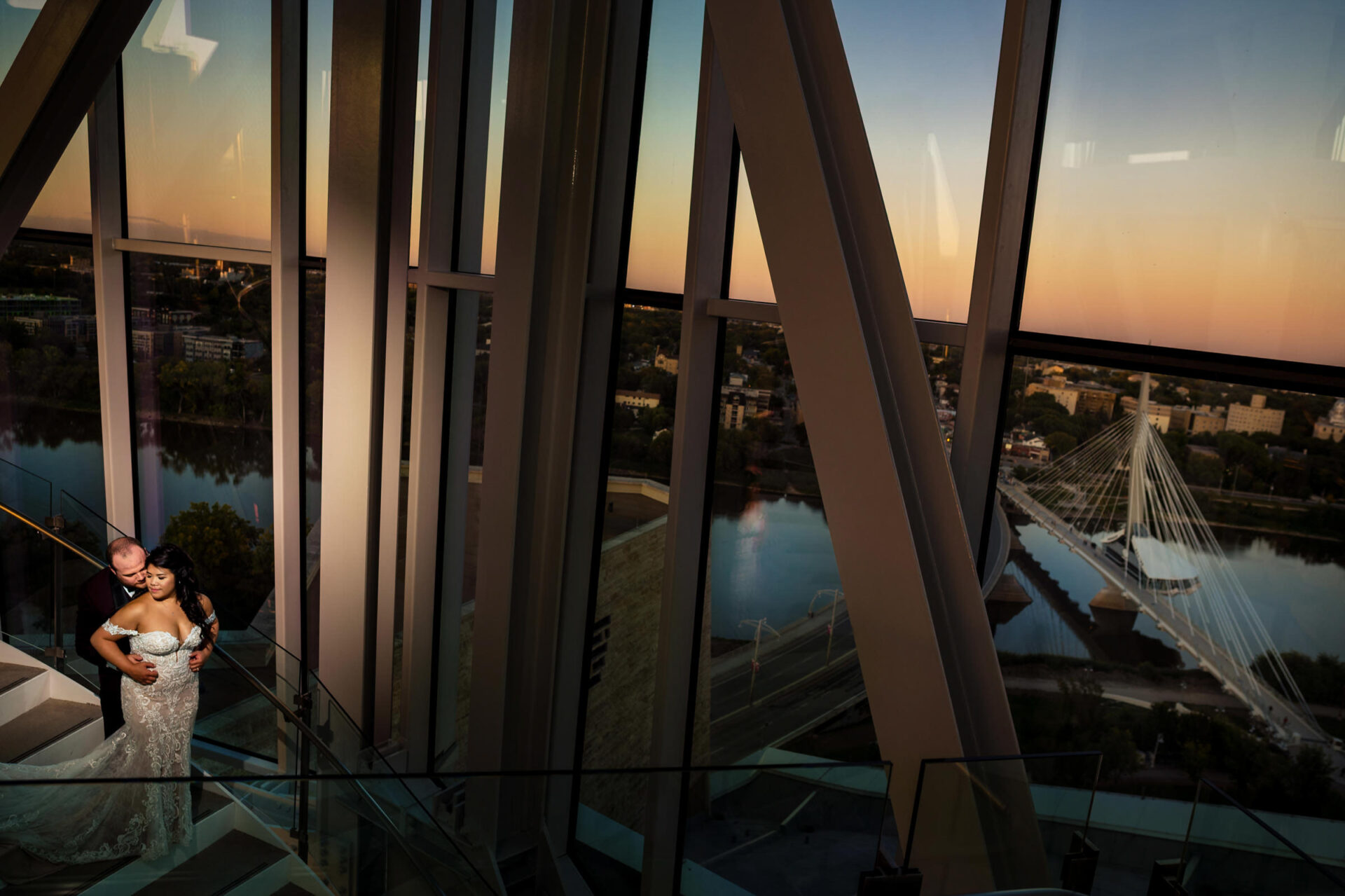 Couple embracing on a stairway, with best Winnipeg wedding photos capturing the view.
