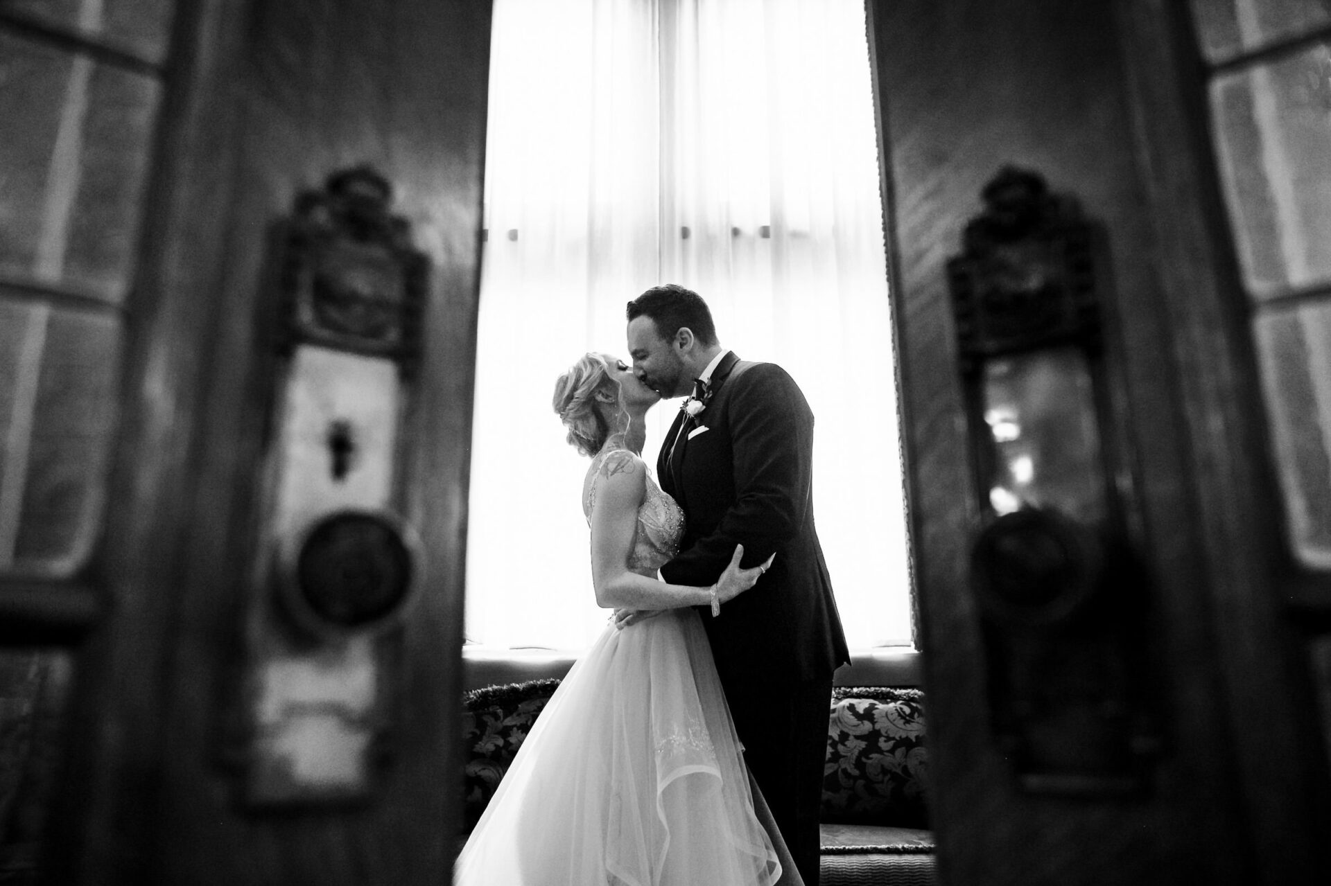 A couple shares a kiss in an elegant room, captured as one of the best Winnipeg wedding photos.