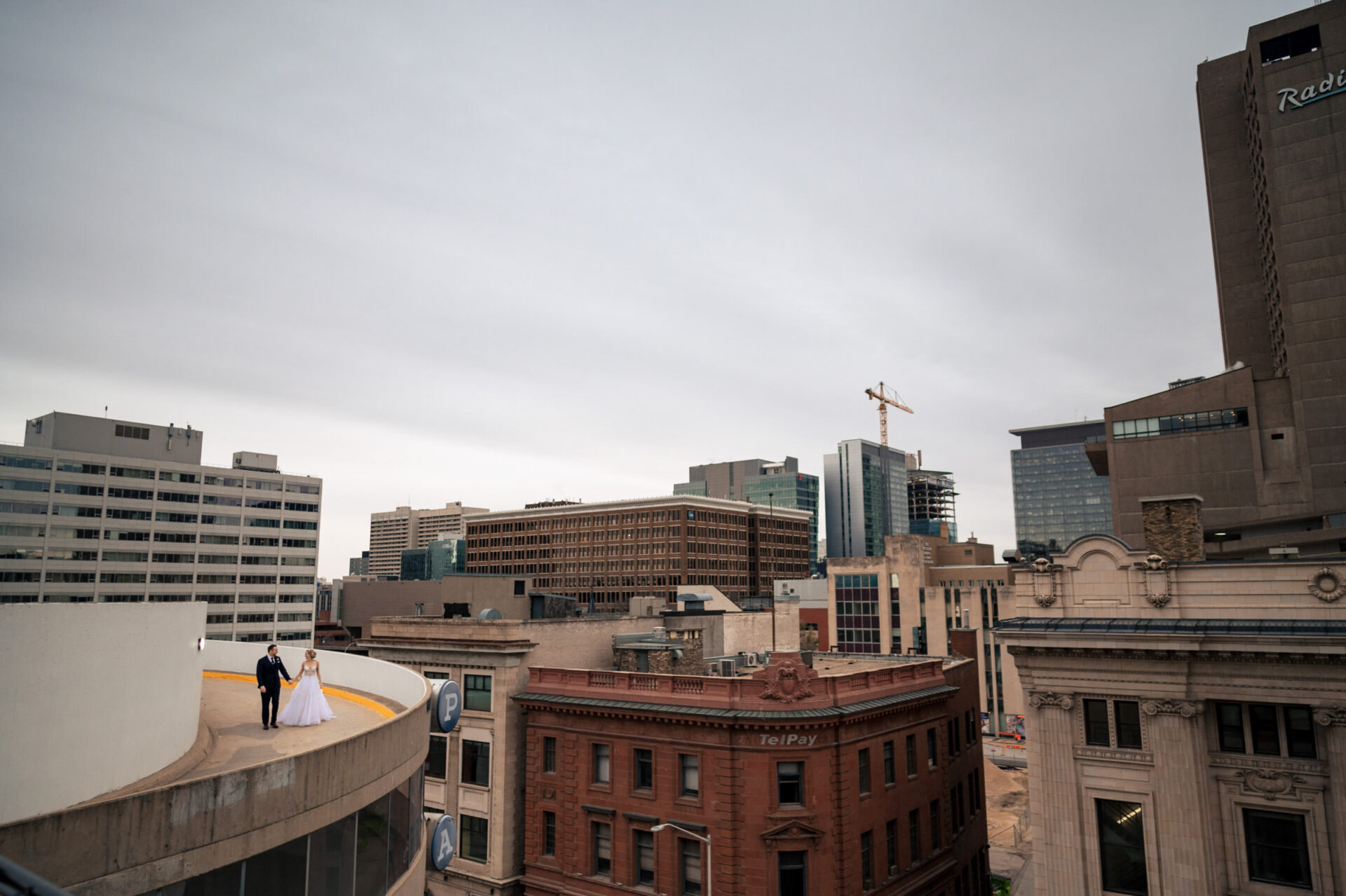 Best Winnipeg wedding photos: Bride and groom on rooftop, cityscape backdrop.