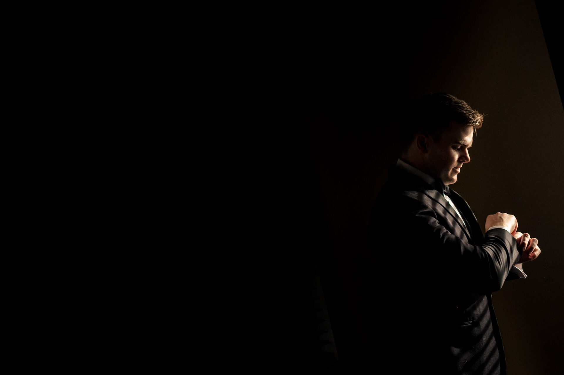 Man in suit adjusting cufflinks, capturing a Best Winnipeg Wedding Photos moment.