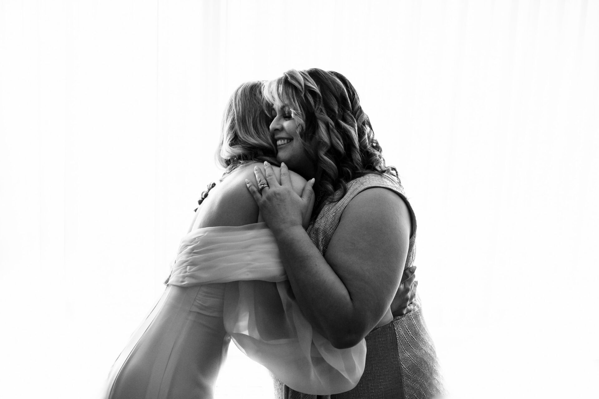 Bride and woman warmly embrace, capturing the best Winnipeg wedding moments.