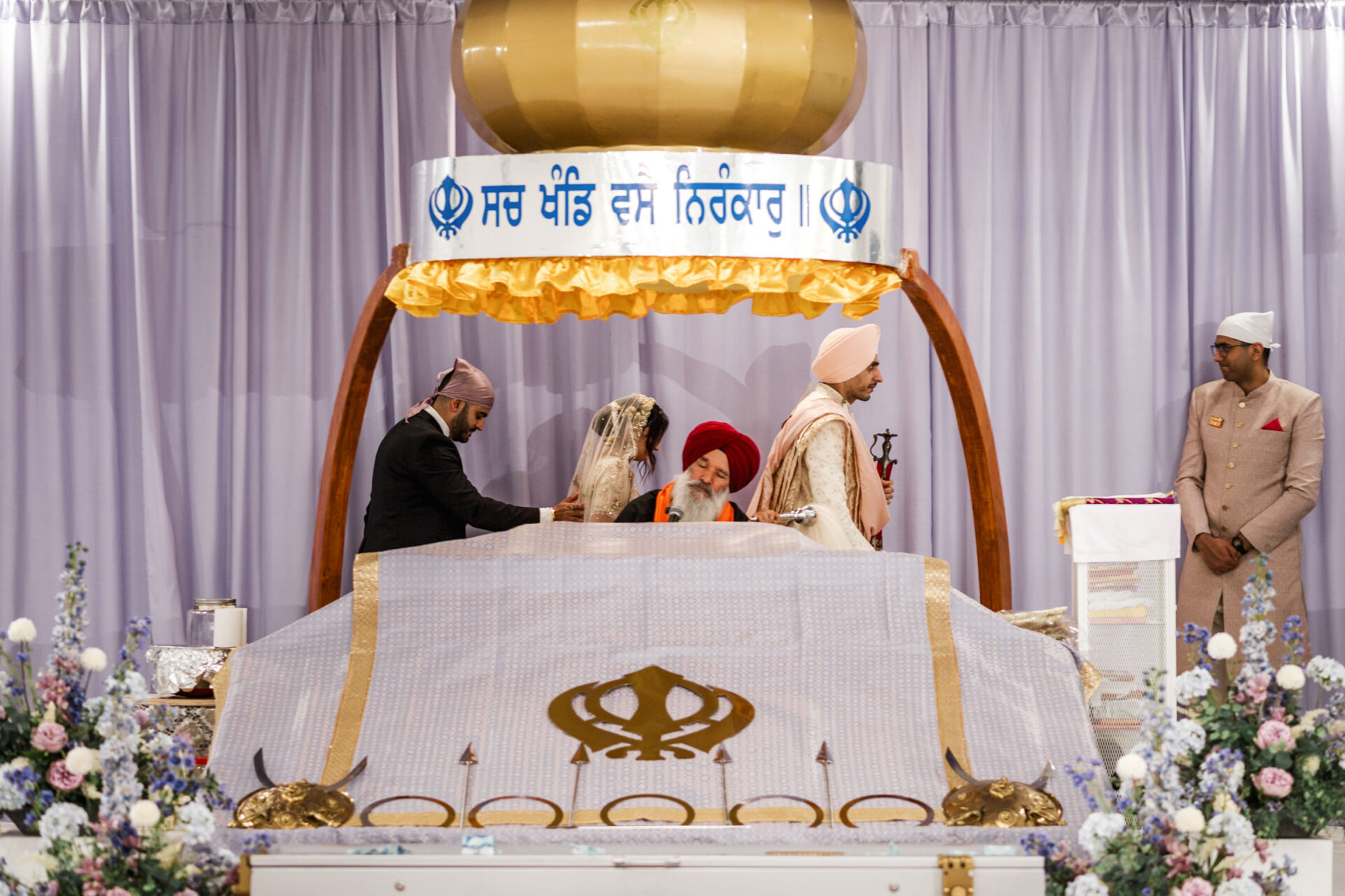 Sikh and Hindu wedding ceremony with a couple inside a beautifully decorated temple.