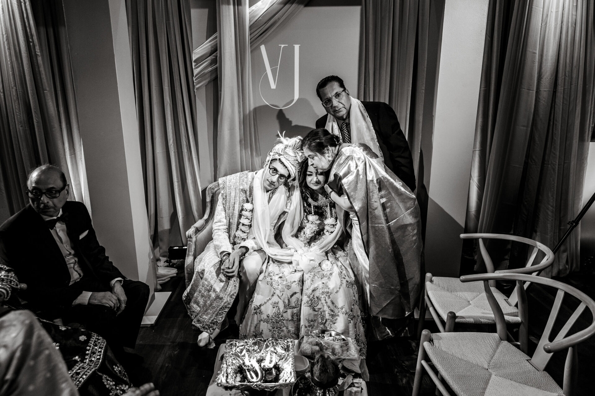 Bride, groom, and family in an intimate moment at a Sikh wedding ceremony.