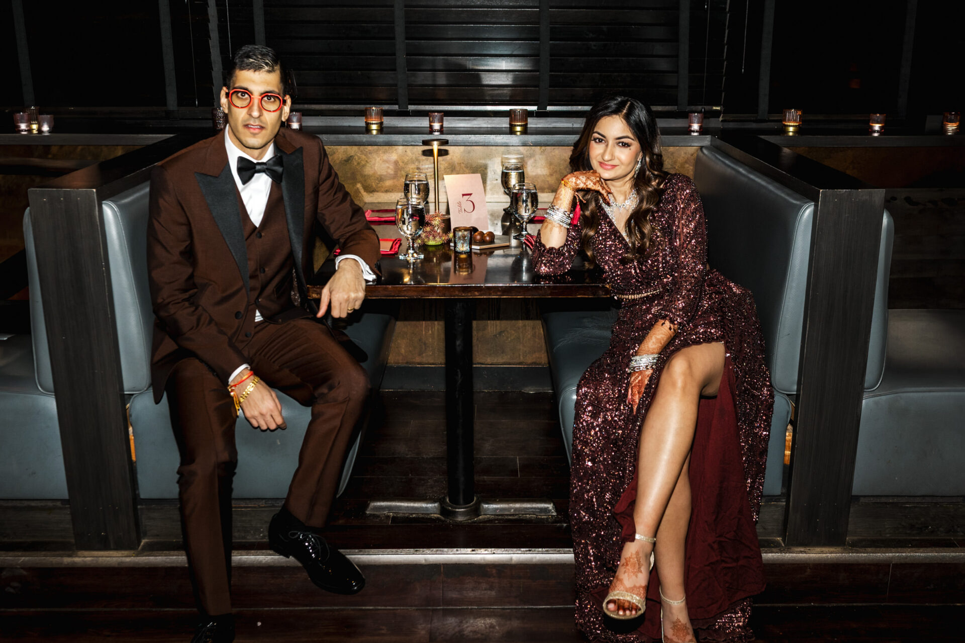 Heartfelt Sikh and Hindu Wedding Winnipeg. A couple in formal attire enjoys a dimly lit restaurant after a grand Sikh wedding.