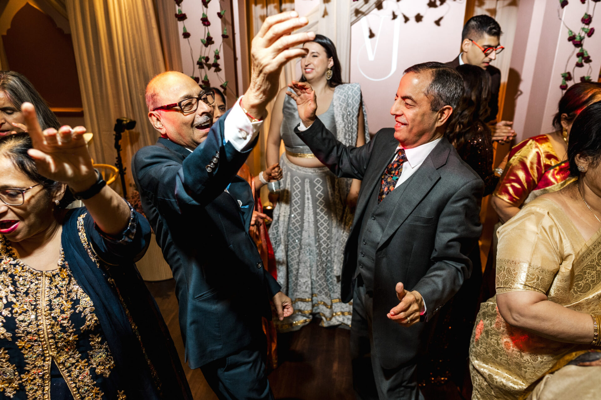 People joyfully dancing at a vibrant Sikh wedding celebration.
