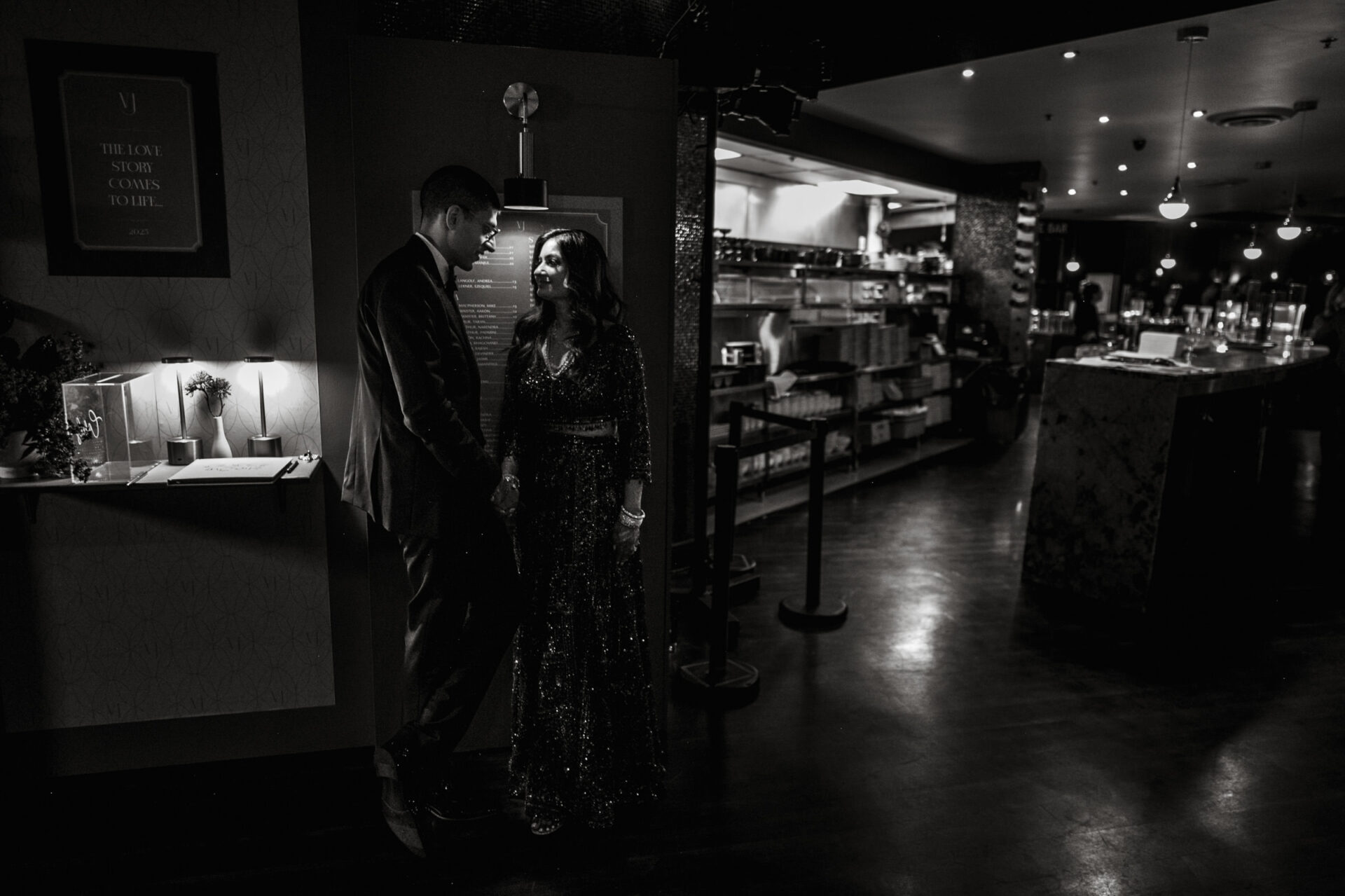 A couple chats in a dimly lit, elegant restaurant after a vibrant Sikh wedding.